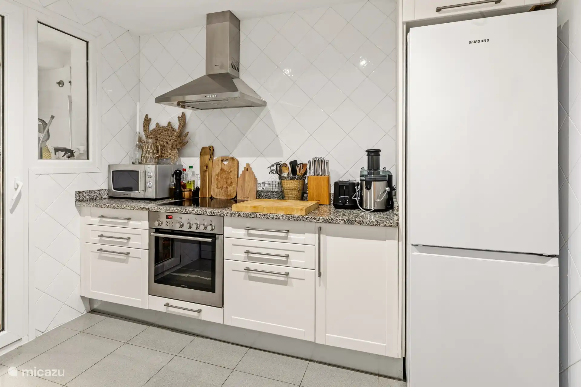 Cuisine avec tout l’équipement nécessaire, puis une buanderie avec machine à laver