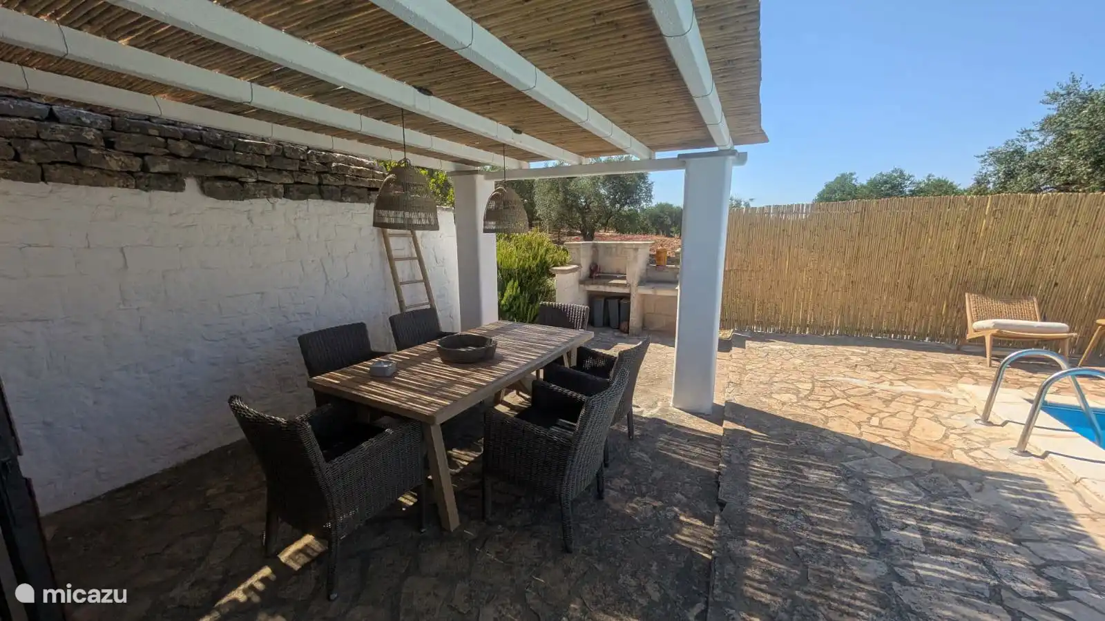 Terraza cubierta con gran mesa de comedor de madera extensible (hasta 12 personas). 