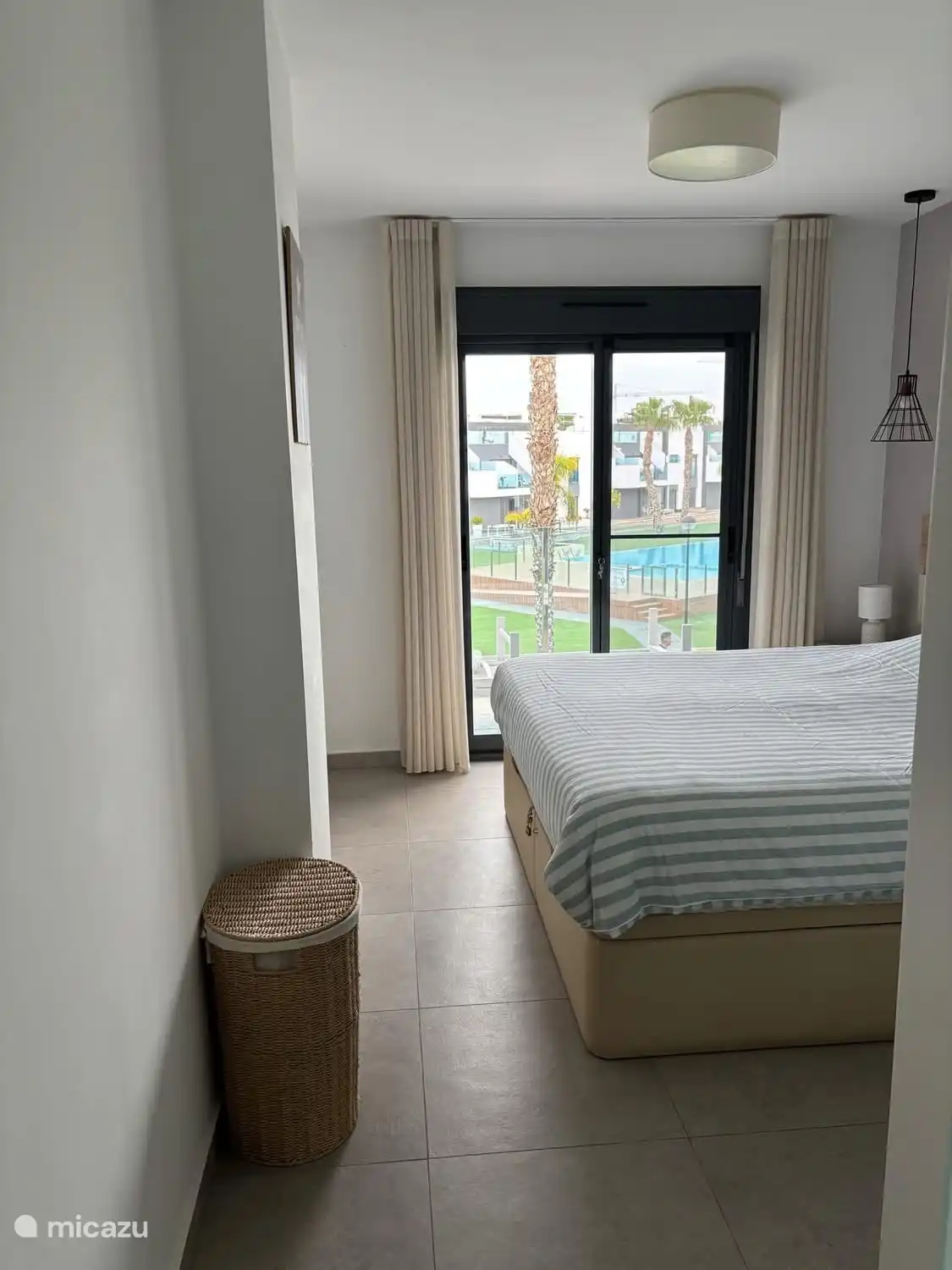 Masterbedroom met zicht op binnentuin en zwembad.