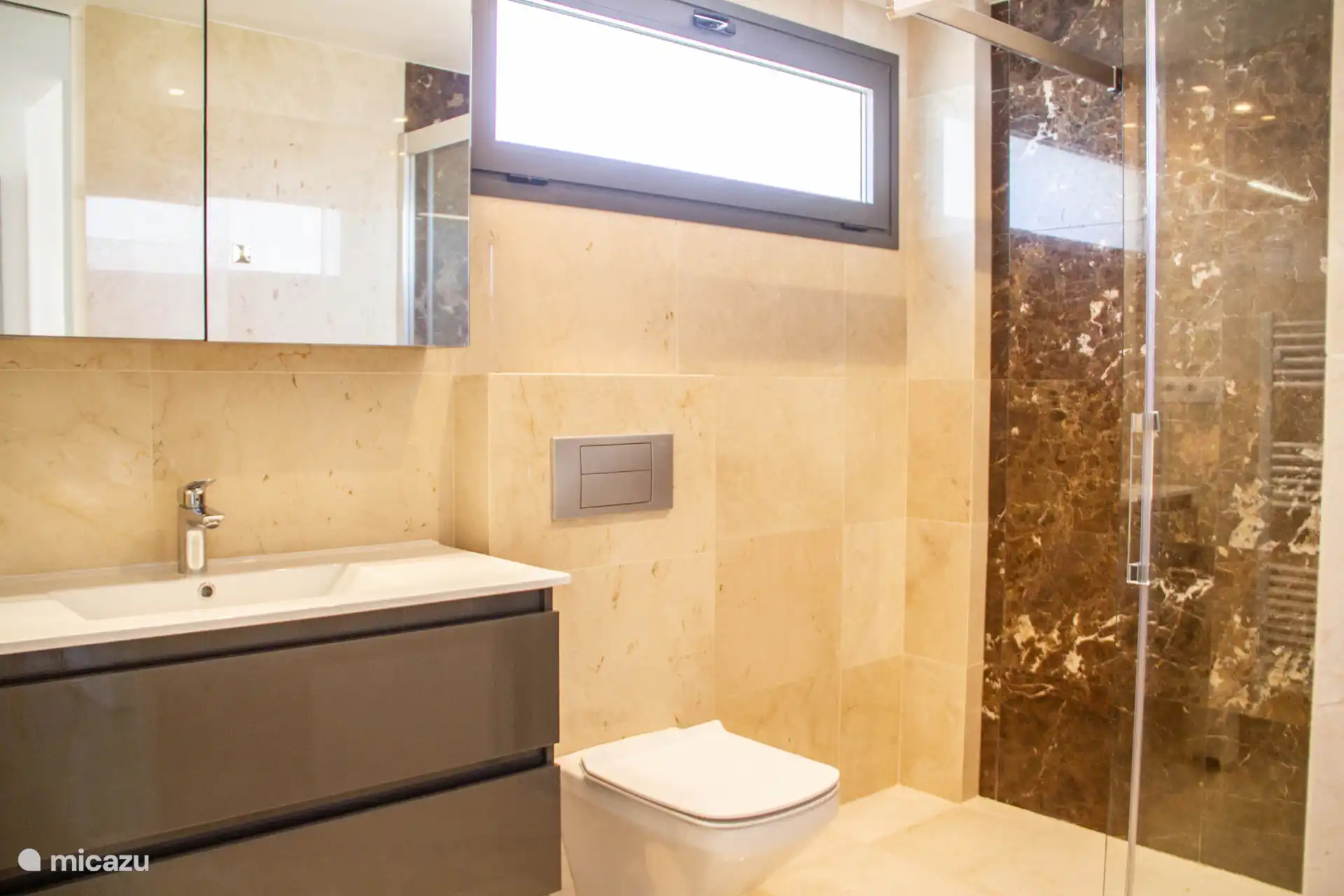 Badezimmer 1 mit Dusche, Waschbecken und WC. 