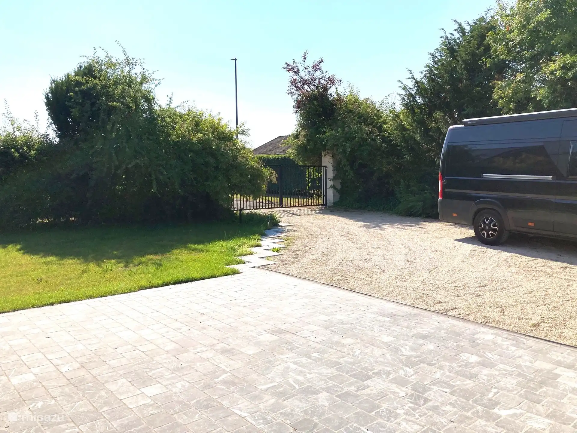 Geautomatiseerd hekken van de afgesloten parking met begin van de private tuin