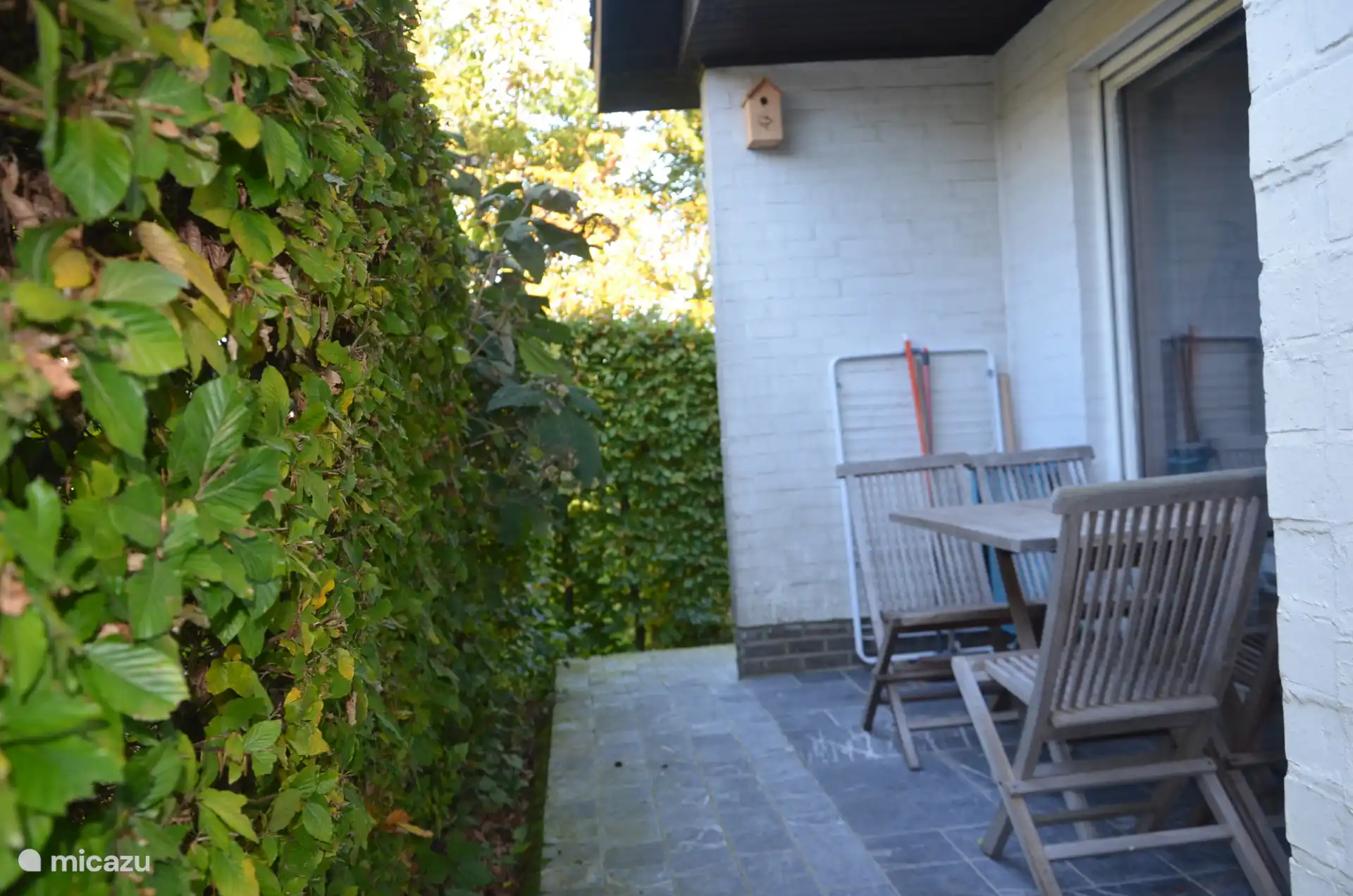 Overdekt ochtendterras aan keuken en schuifraam living