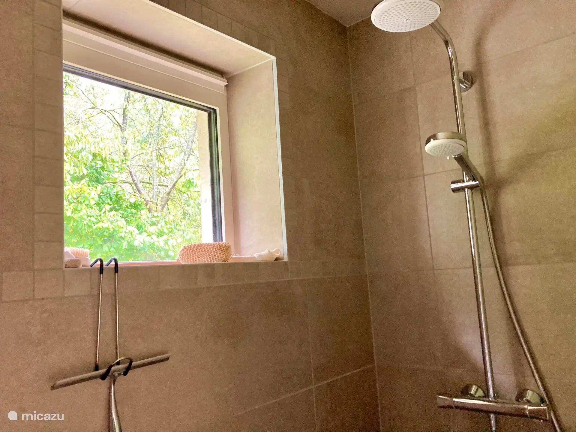 regendouche met zicht op de tuin en het terras