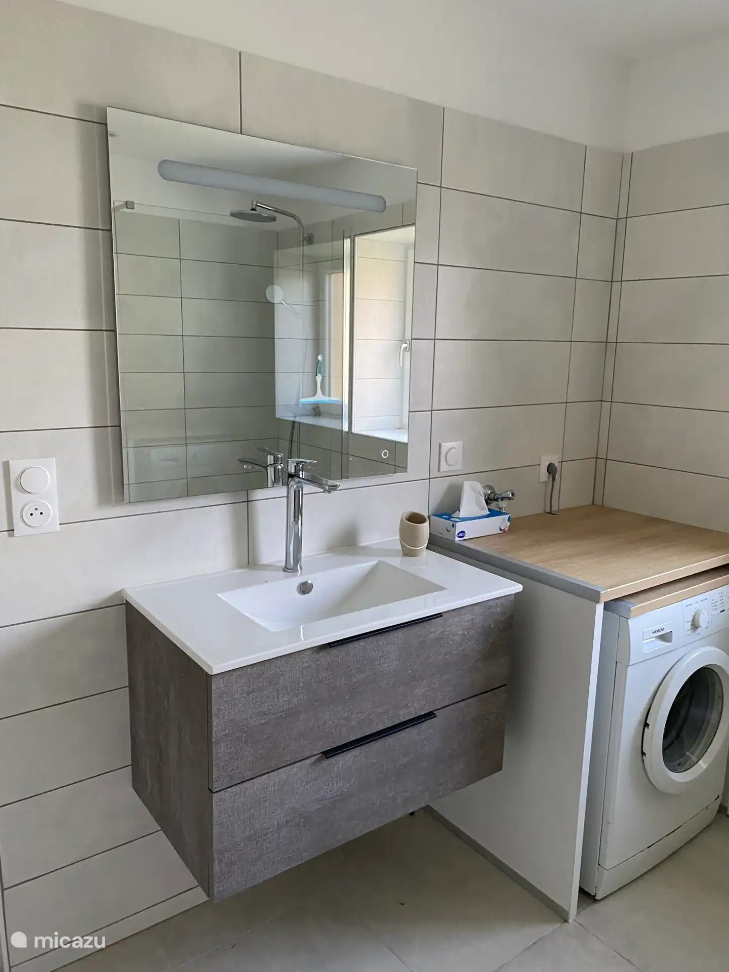 Geräumiges Badezimmer mit Unterschrank und Waschmaschine