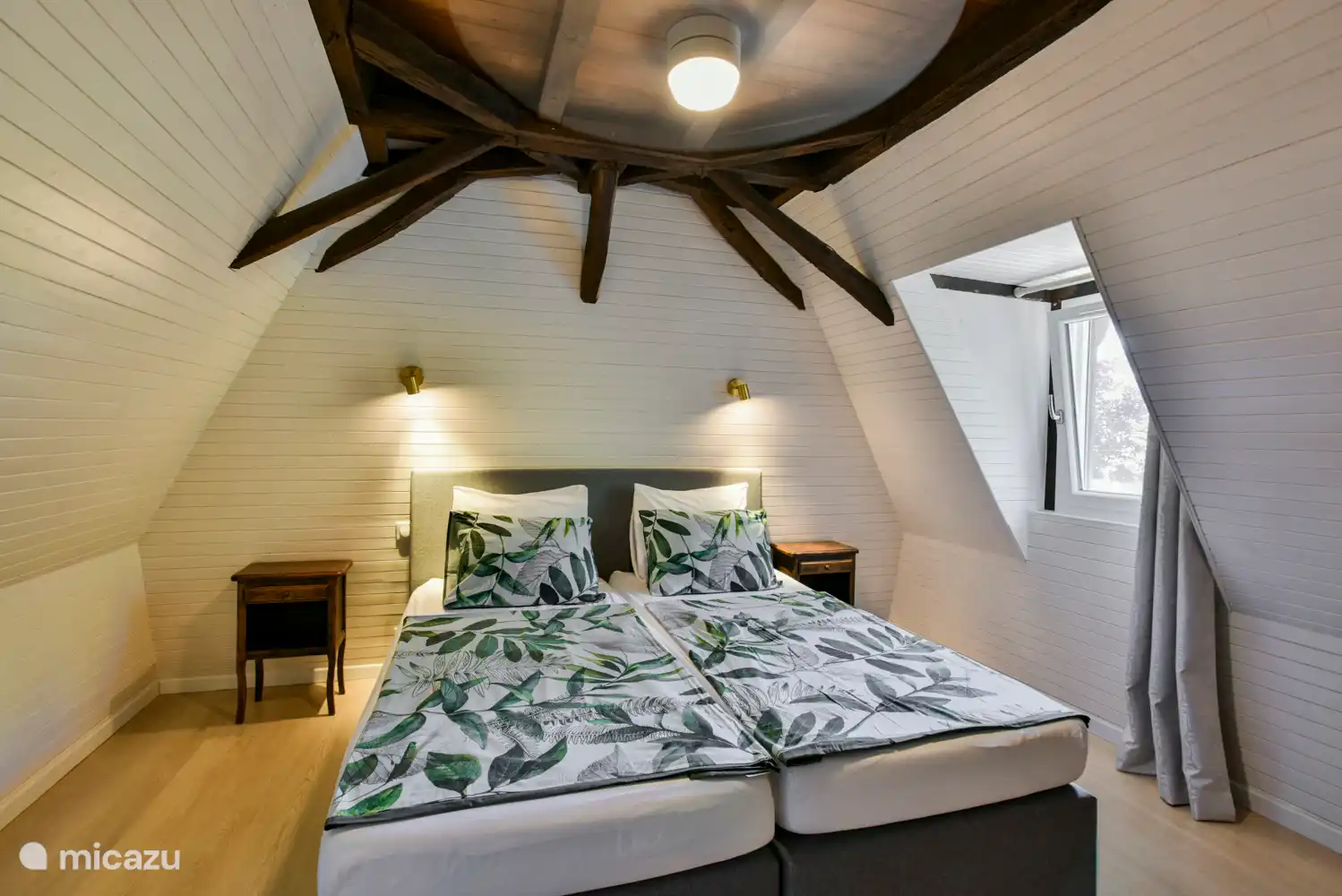 Schlafzimmer unter der Balkendecke mit Boxspring (180x200), Stauraum, Deckenventilator und Fliegengitter. 