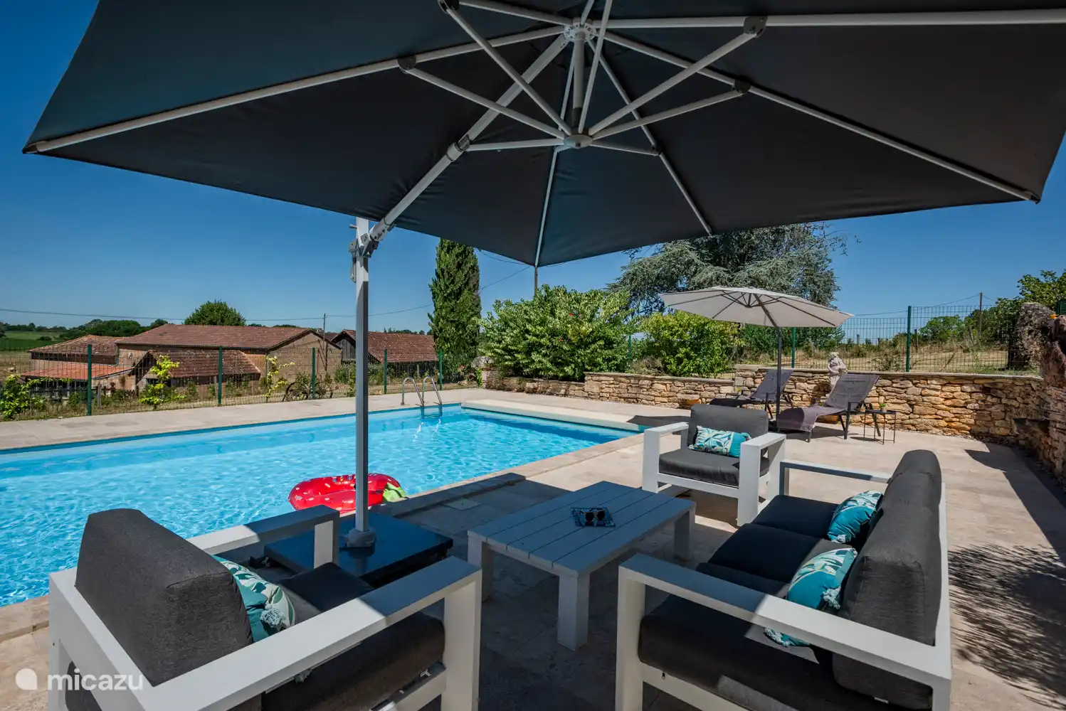 Großes beheiztes Schwimmbecken, Sonnenplattform mit Blick über den Hügel, Lounge-Sofa und Sonnenliege.