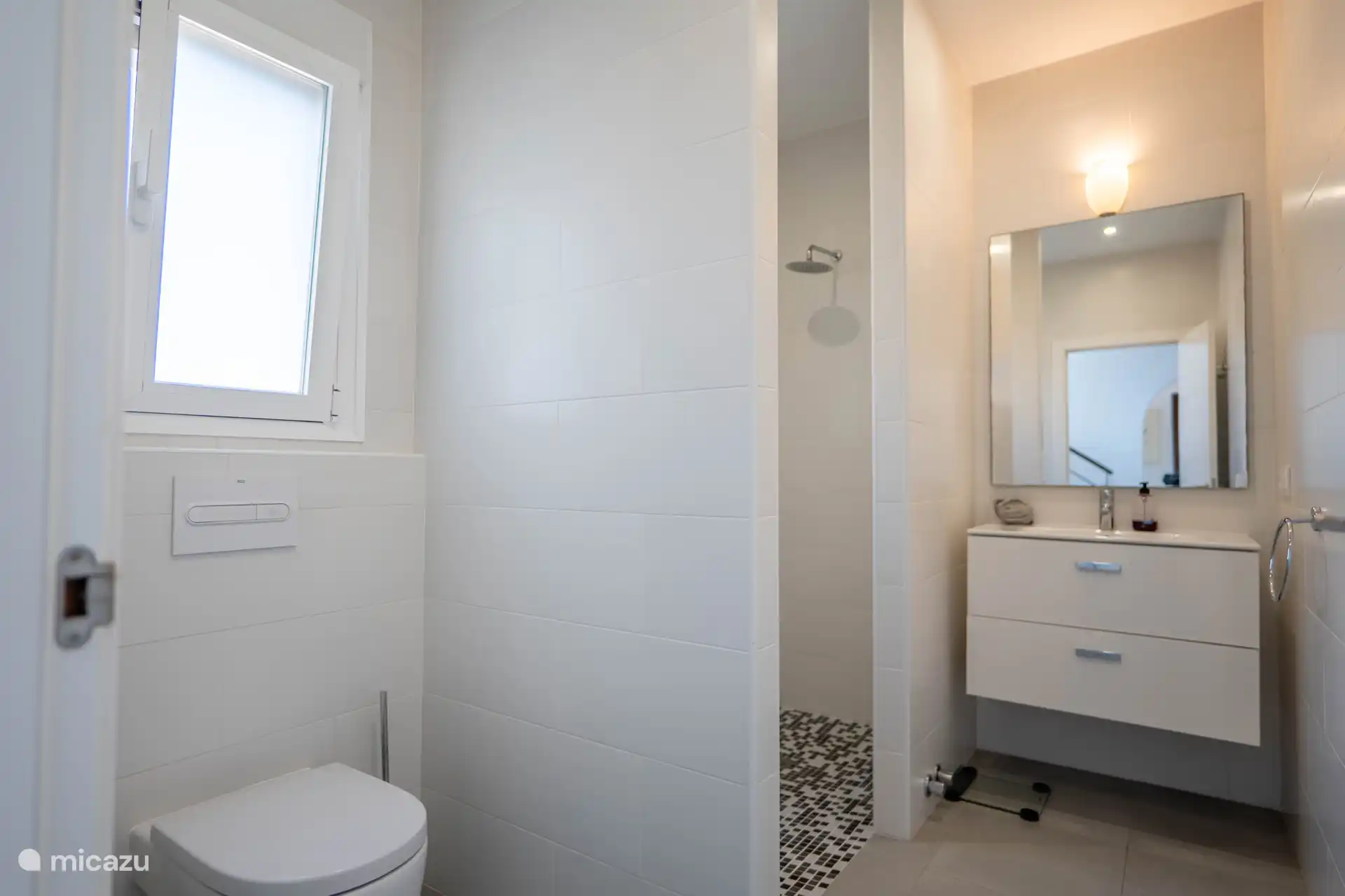 The bathroom has a shower, toilet and sink.