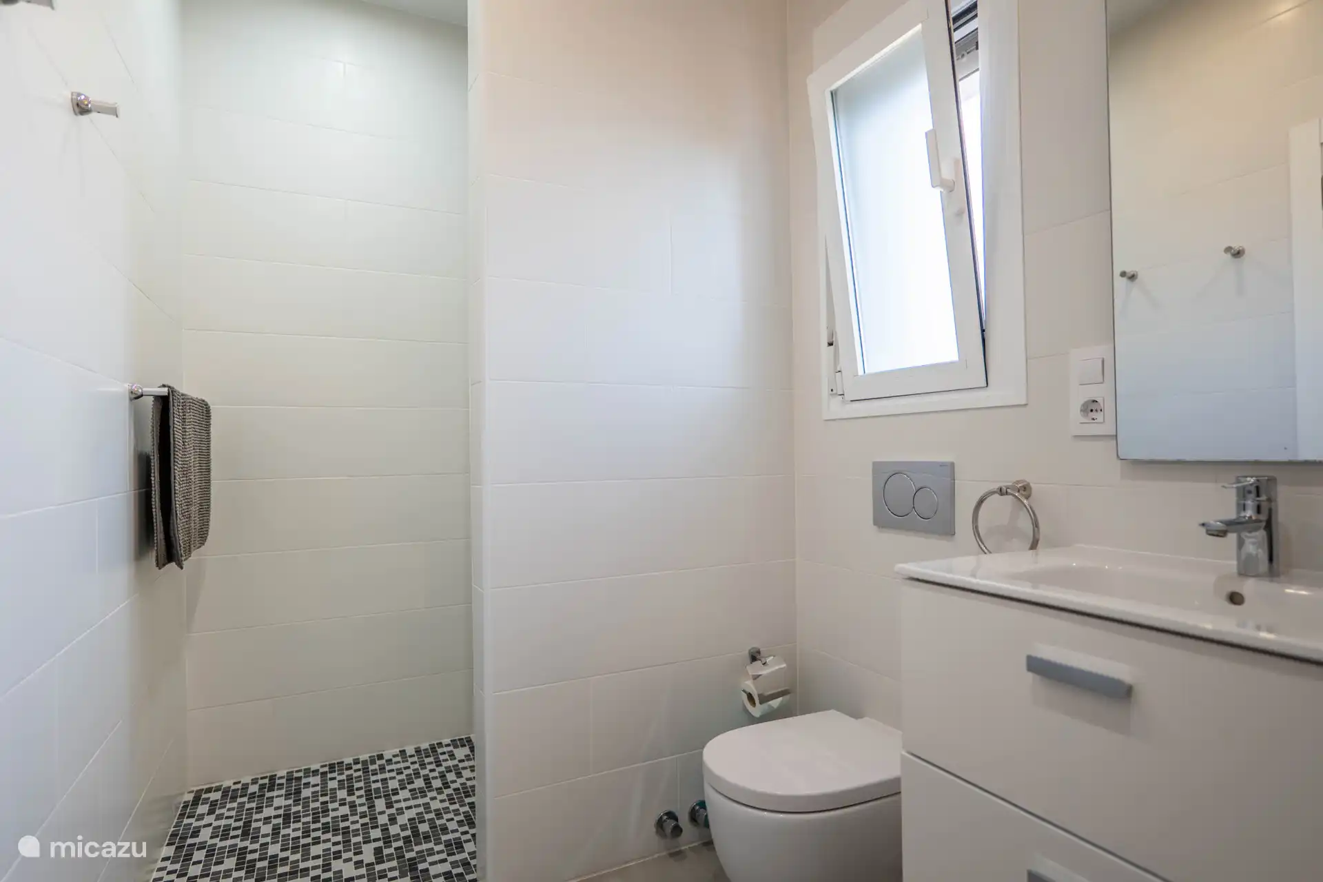 Which is equipped with a shower, bath, two sinks and a toilet.