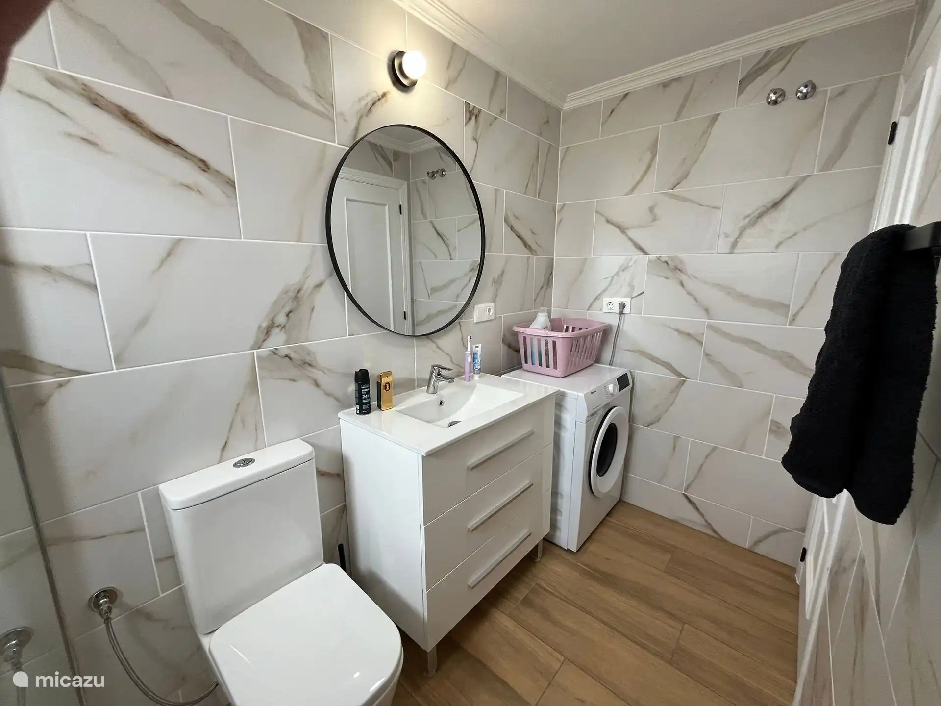 Salle de bain avec douche à l’italienne, toilettes, lavabo et machine à laver