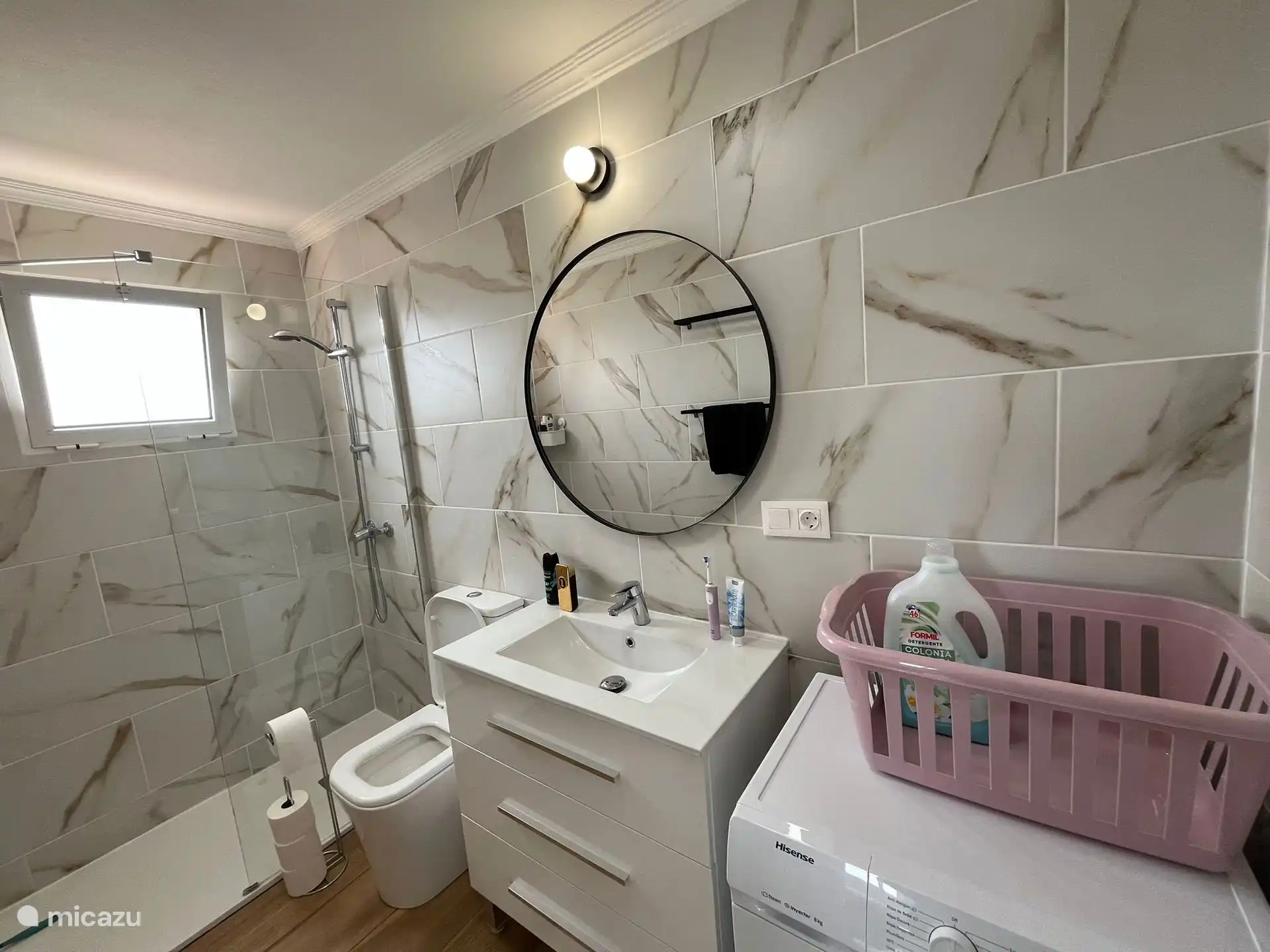 Salle de bain avec douche à l’italienne, toilettes, lavabo et machine à laver