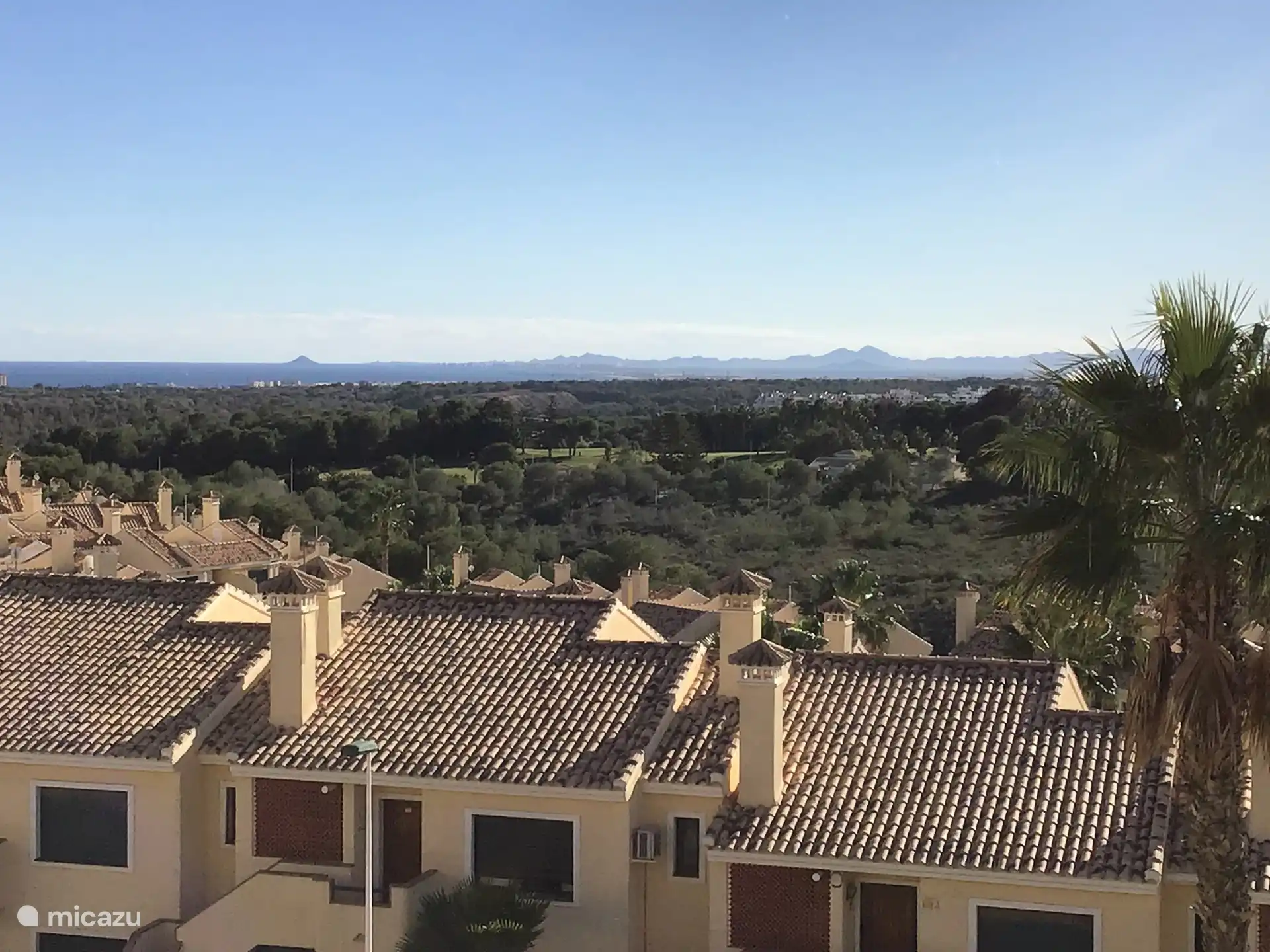 Uitzicht vanaf het balkon op de golfbaan en de zee.