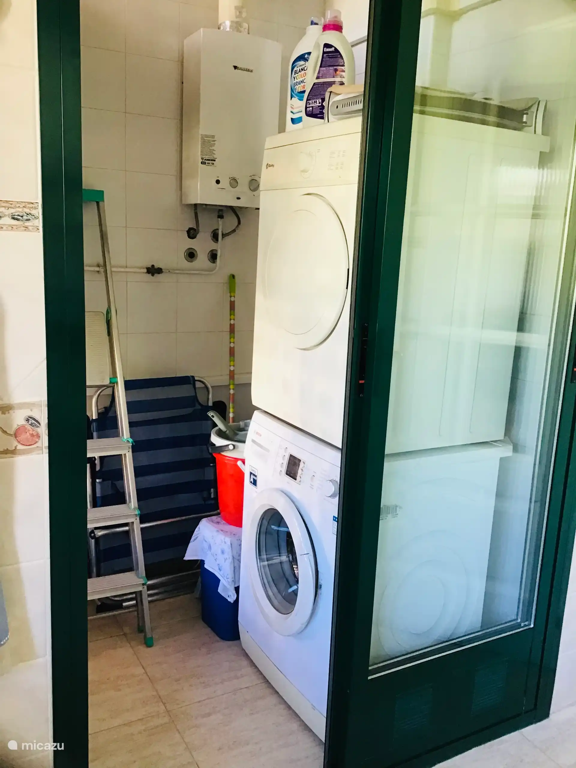 Bijkeuken aangrenzend aan de keuken met o.a. wasmachine en wasdroger.