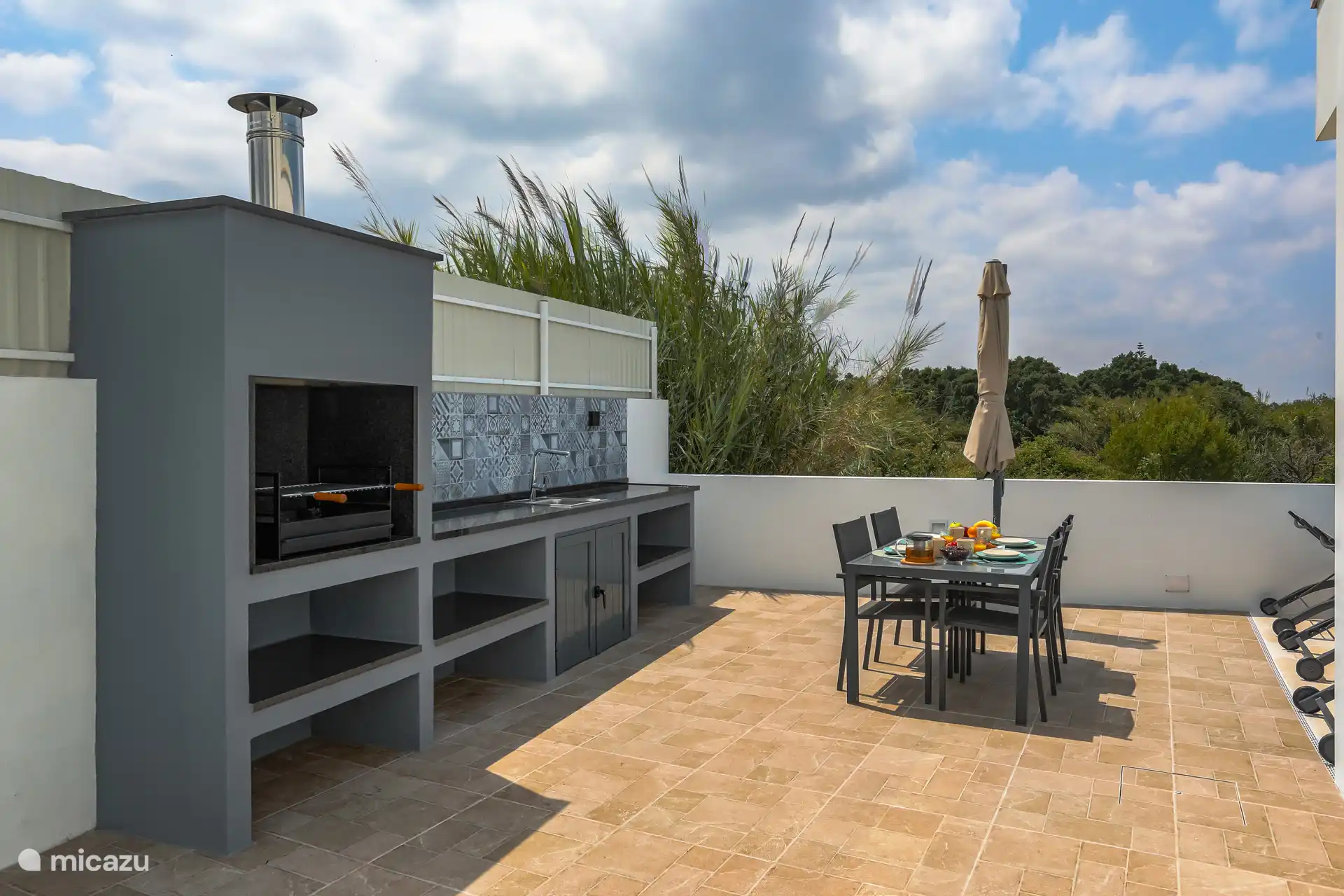 La spacieuse terrasse en bas est au soleil toute la journée (sud-ouest) et donne une vue sur la piscine. L’endroit idéal pour manger à l’extérieur le matin ou faire un barbecue le soir.