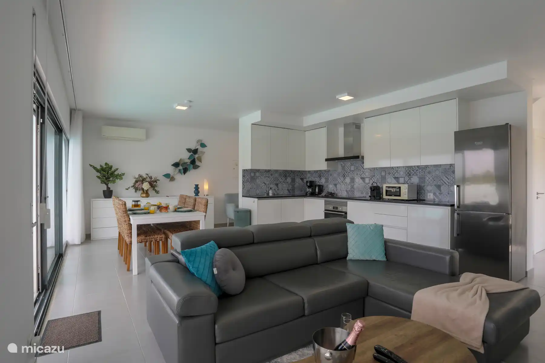 Salon avec cuisine ouverte et accès direct au jardin. 