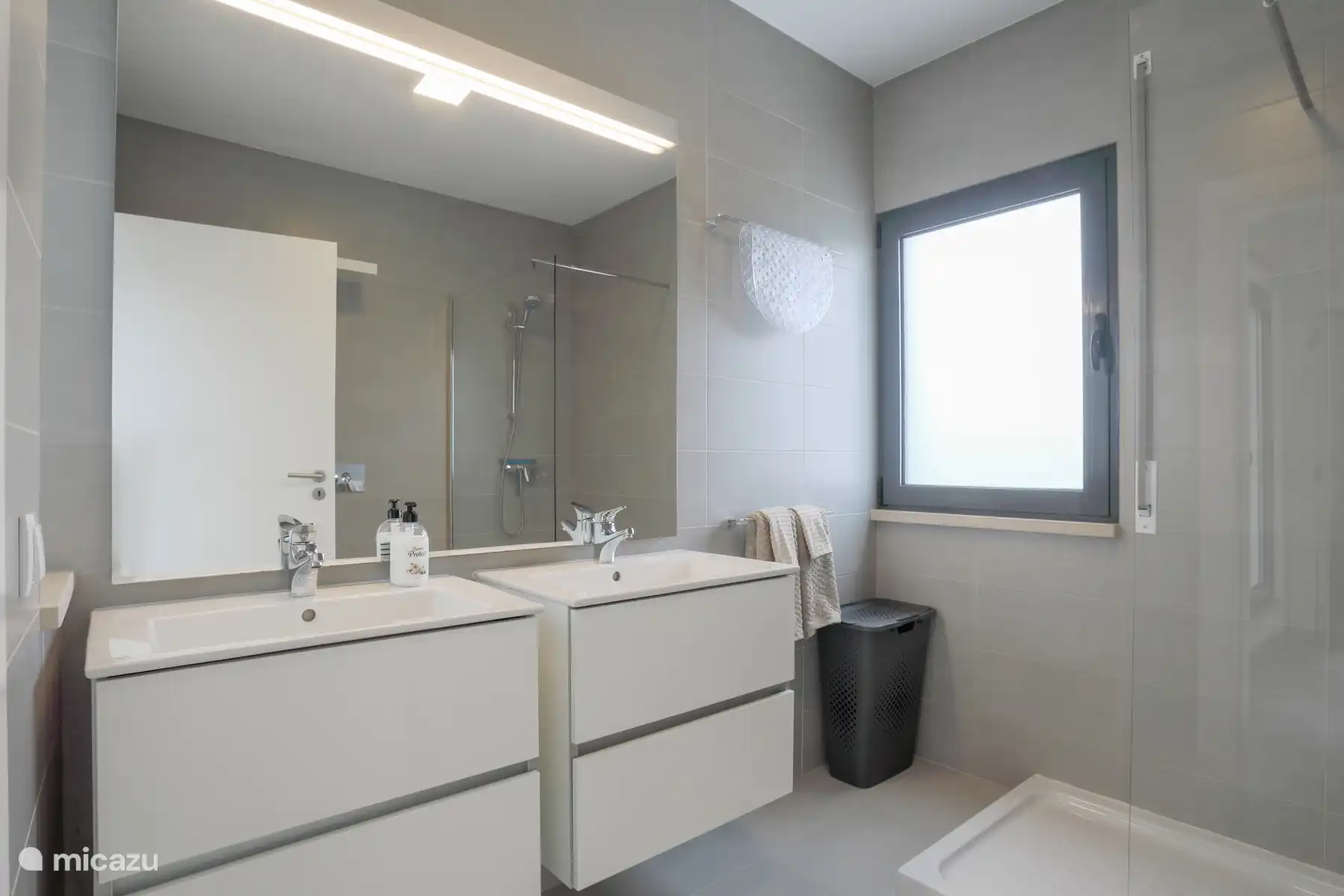 Salle de bain au premier étage avec douche, WC et deux lavabos. 