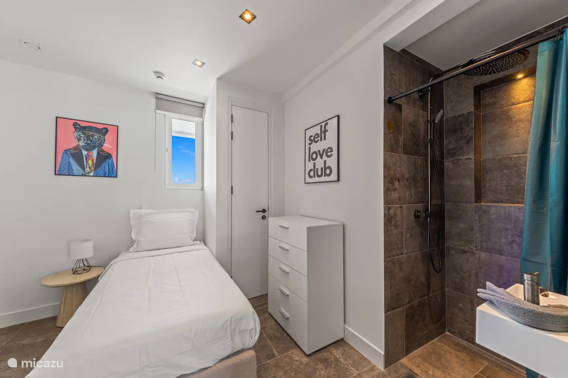 Gasten slaapkamer met eigen wastafel en douche. 