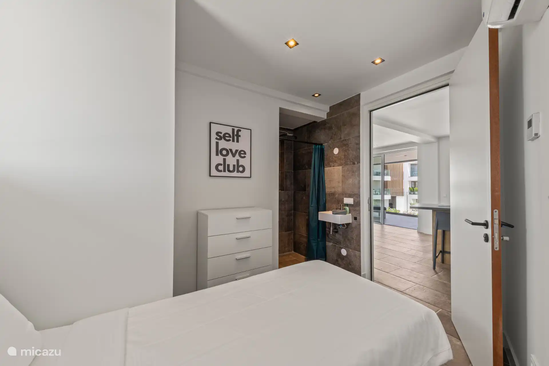 Eenpersoons slaapkamer met eigen wastafel en douche. 