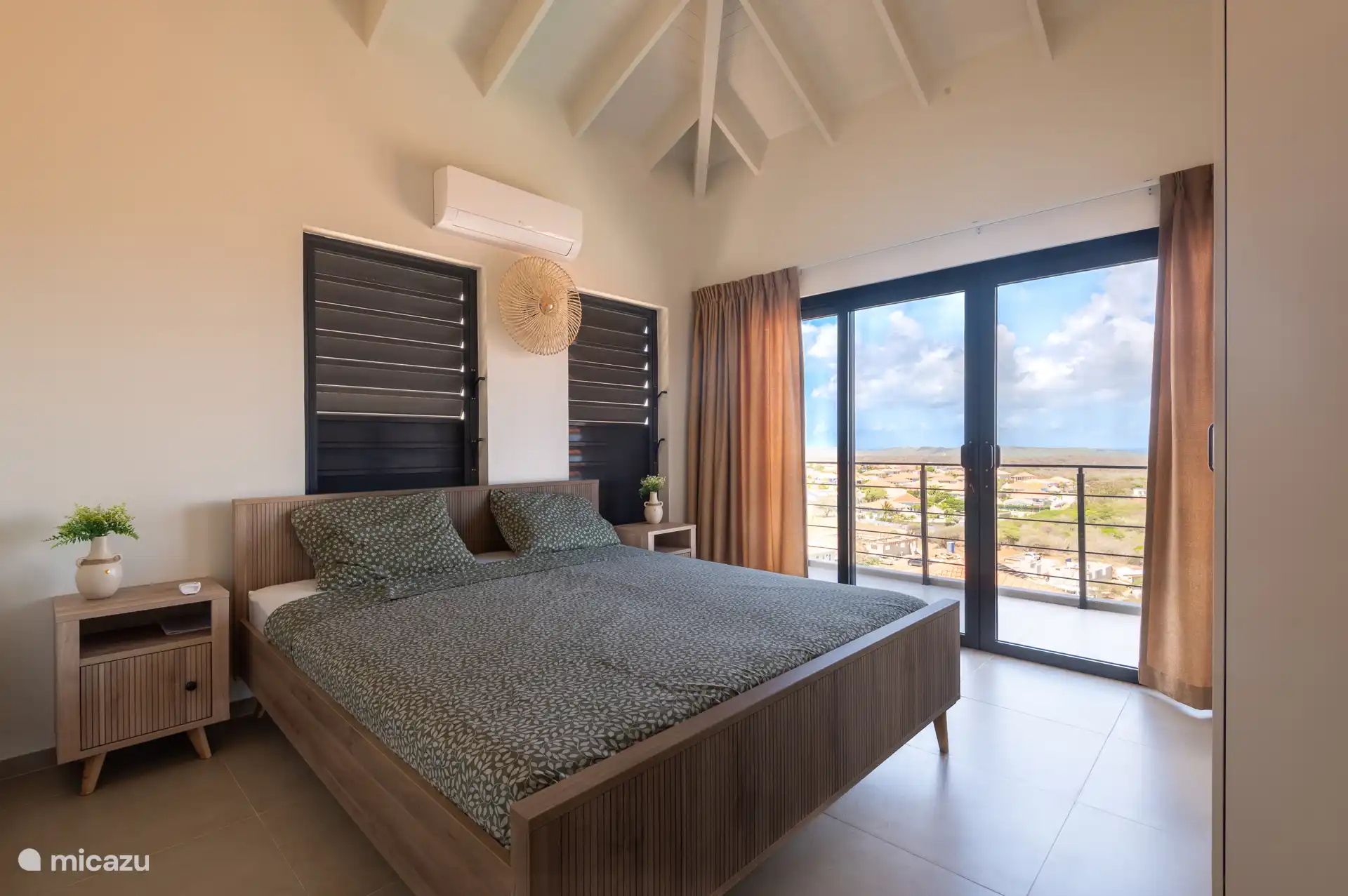 Großes Schlafzimmer mit Schiebetüren zum Außenbalkon