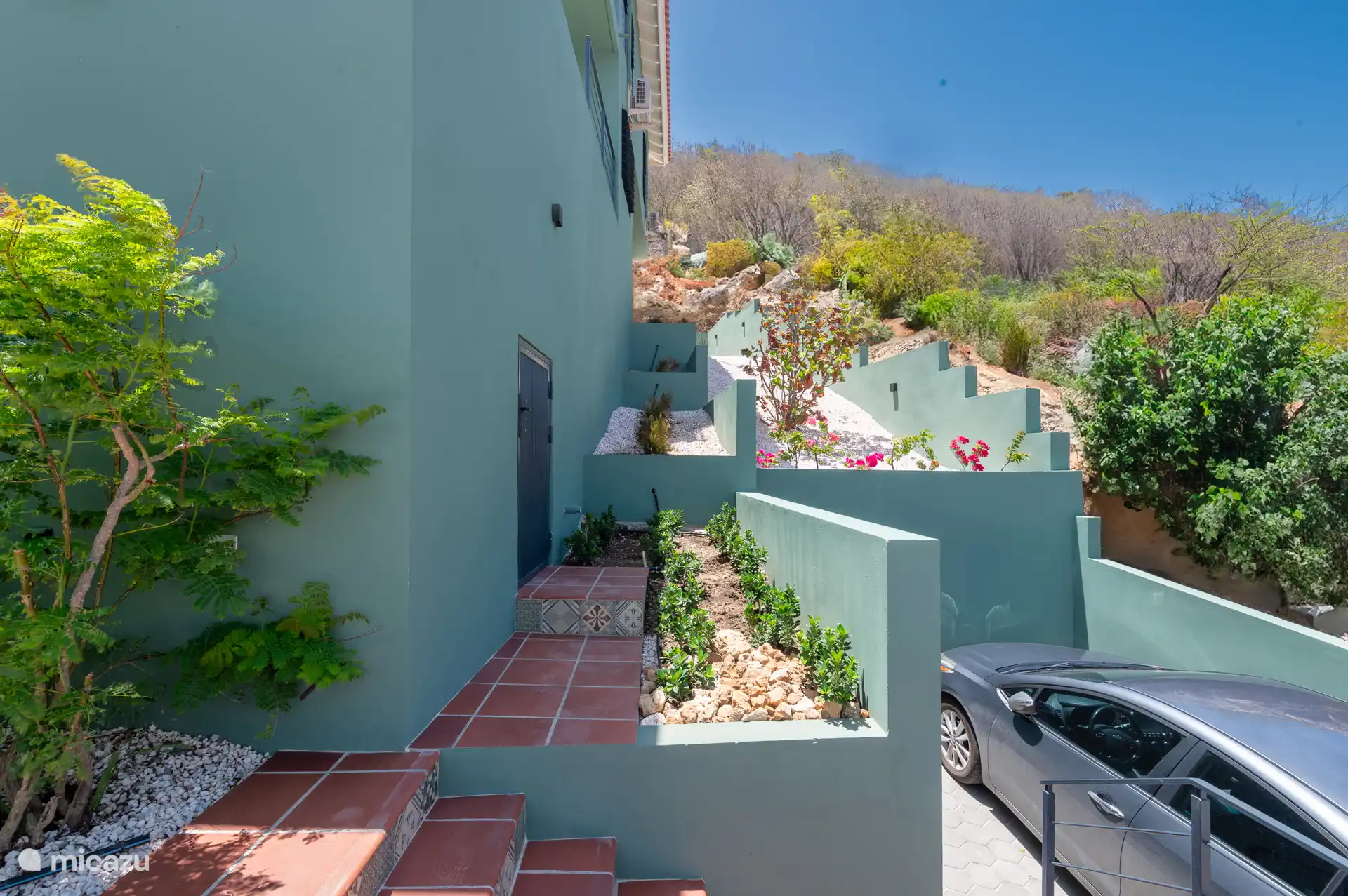 Seite der Villa mit Platz für das Auto