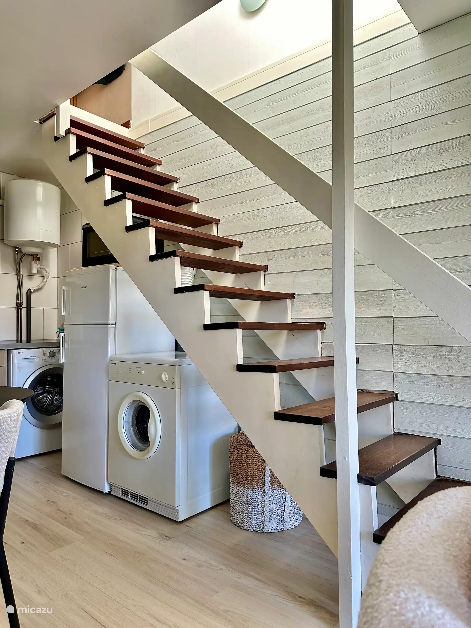 Le réfrigérateur avec compartiment congélateur et le sèche-linge se trouvent sous le trep