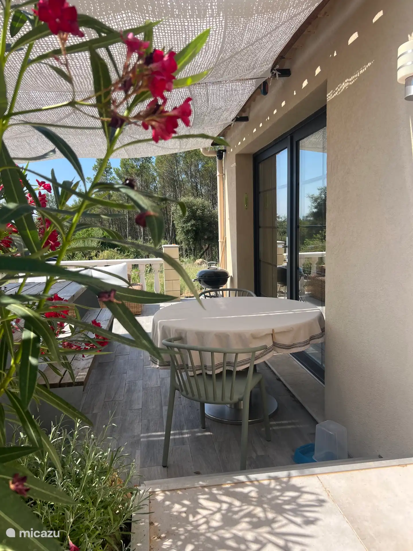 Het terras is voorzien van een ronde tafel met een doorsnede van 140cm. Rondom staan mooie planten en kruiden voor heerlijke geuren en privacy.