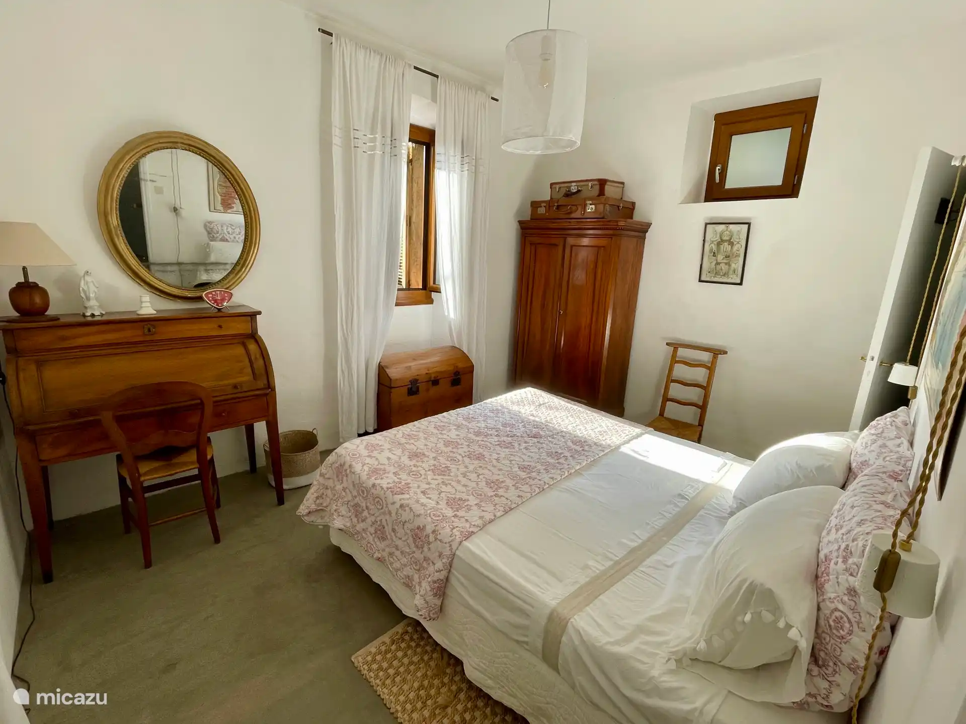 Room overlooking the flowered courtyard, view of the old chapel of the village