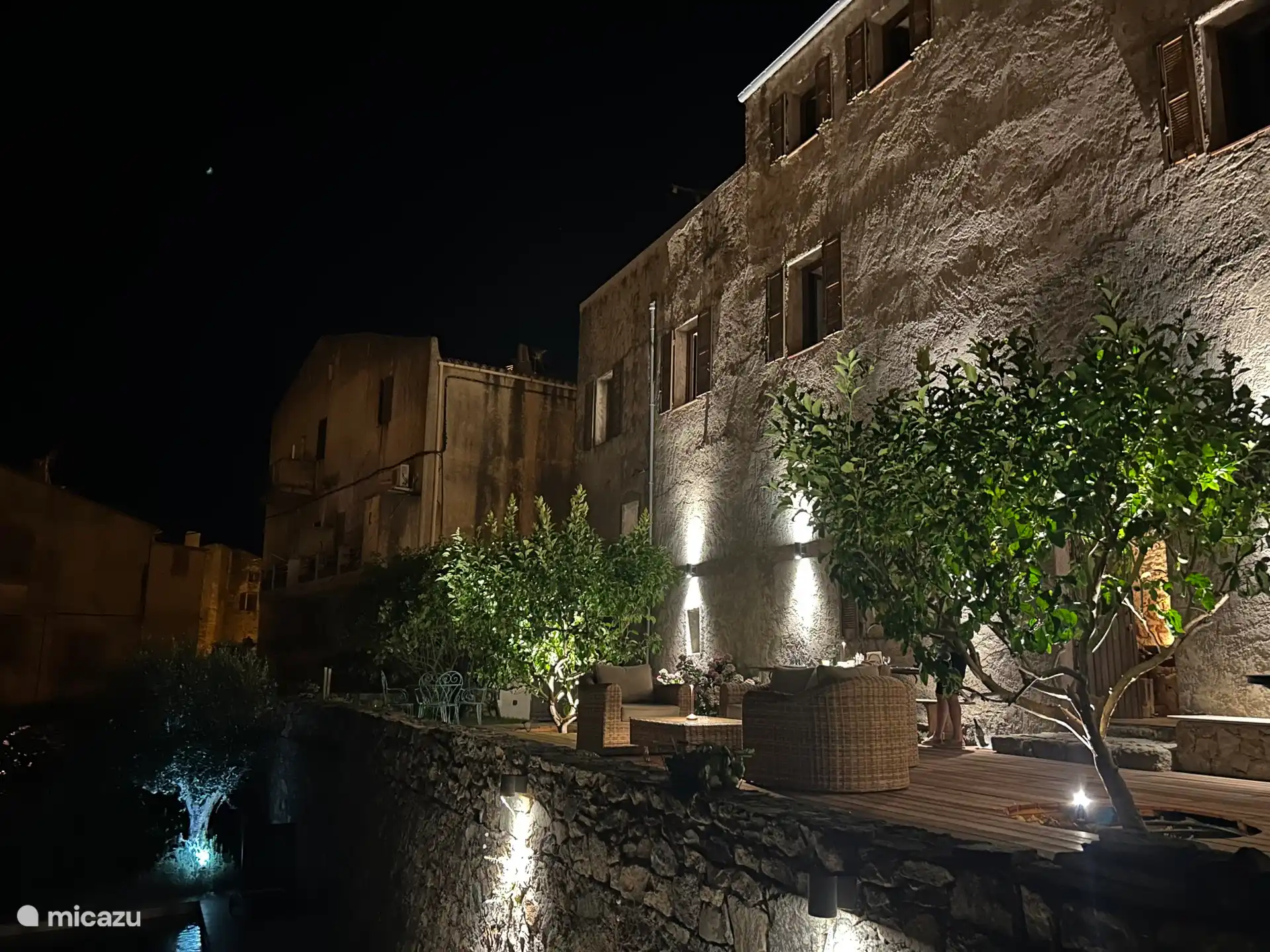 Blick auf das Haus bei Nacht, das Becken auf der inneren Terrasse