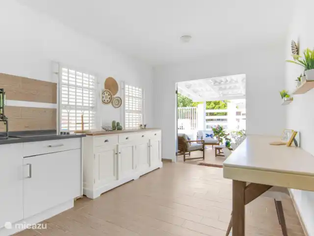 SOMETHING ELS huren in Curaçao, Banda Ariba (oost), Marie Pampoen - vakantiehuis Espaciosa y luminosa sala de estar conectada a la cocina, con un estilo moderno y acogedor. El lugar perfecto para reunirse, compartir comidas y crear recuerdos familiares.