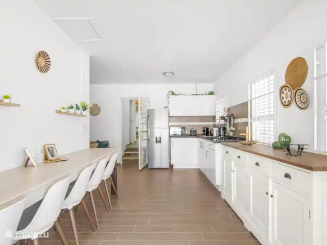 SOMETHING ELS huren in Curaçao, Banda Ariba (oost), Marie Pampoen - vakantiehuis Espaciosa y luminosa sala de estar conectada a la cocina, con un estilo moderno y acogedor. El lugar perfecto para reunirse, compartir comidas y crear recuerdos familiares.