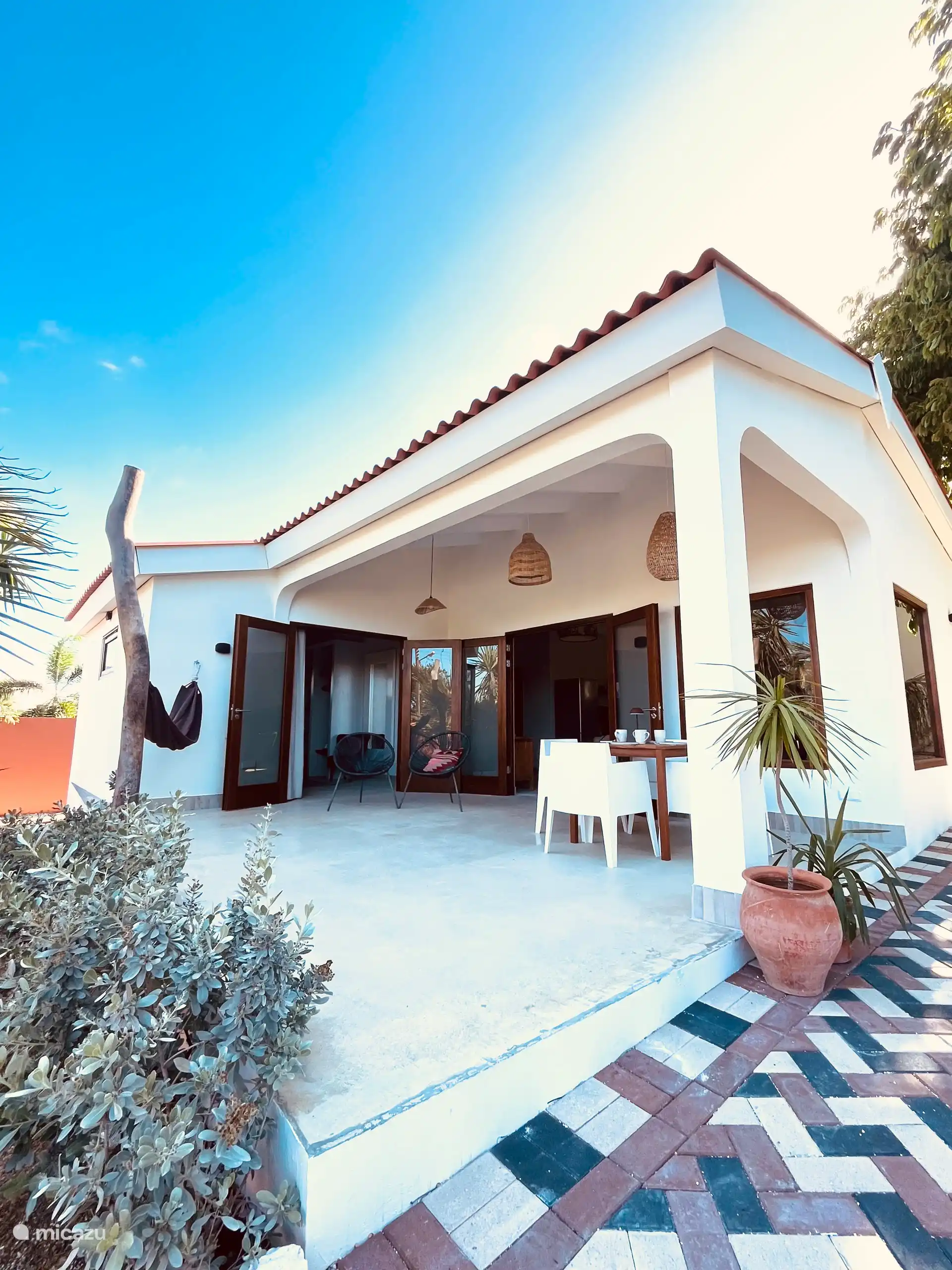 La terrasse est accessible par deux portes-fenêtres et offre une vue sur le jardin tropical verdoyant et le monastère historique. Gazouillis d’oiseaux, papillons, au loin le hennissement des chevaux.