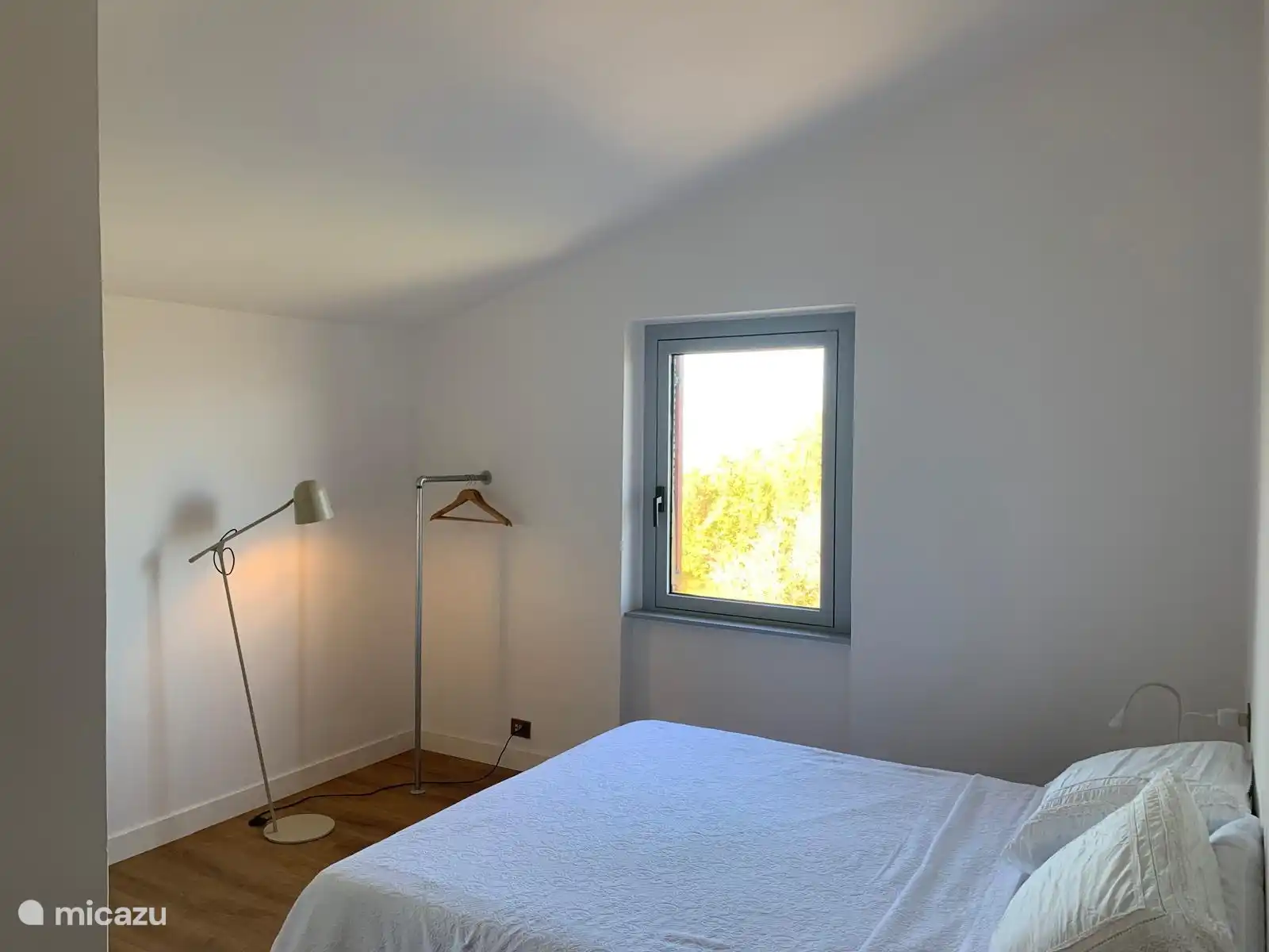 Slaapkamer met tweepersoons boxspring en badkamer