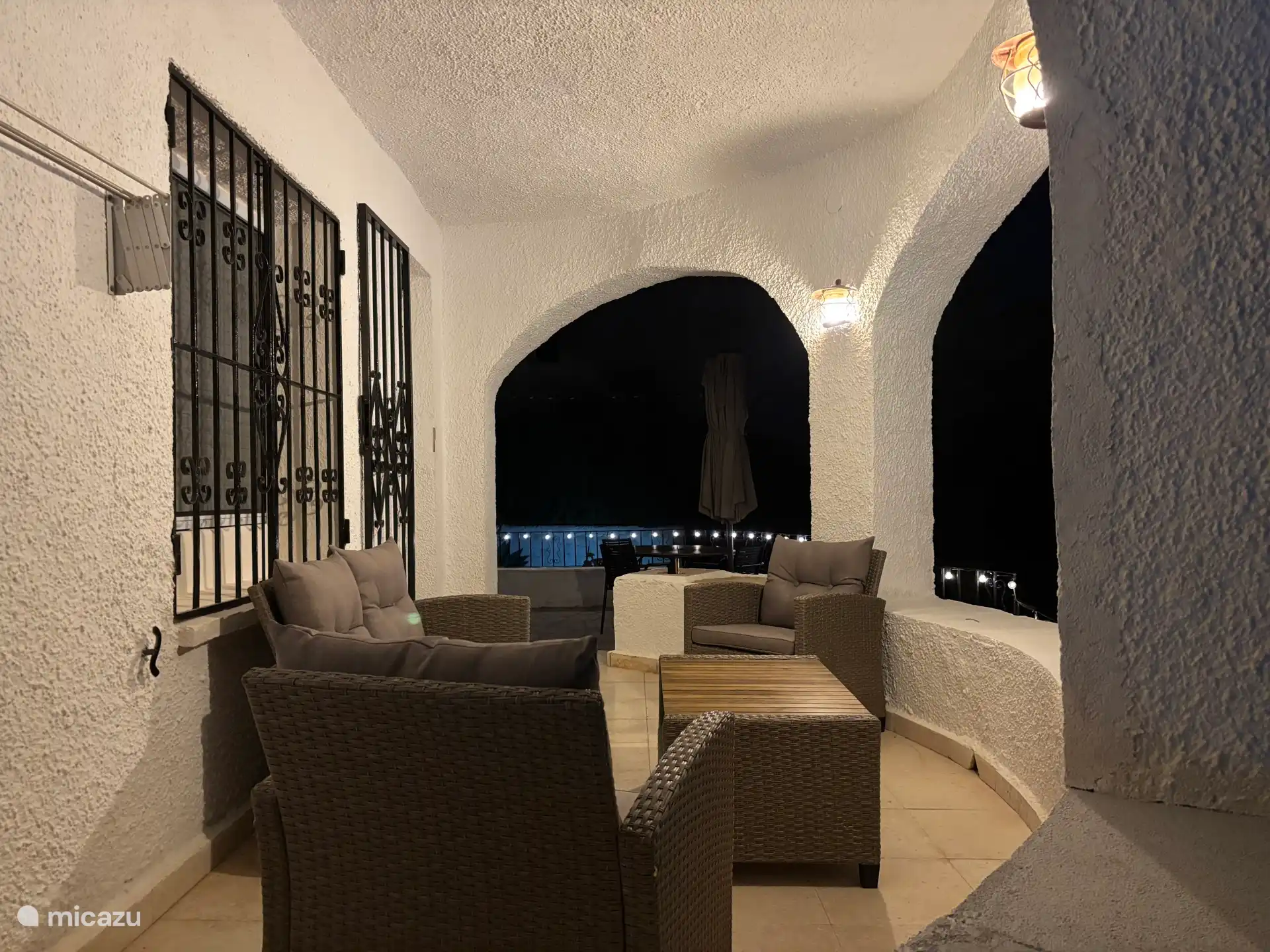 Heerlijk overdekt terras voor het appartement in de avond met sfeer verlichting.