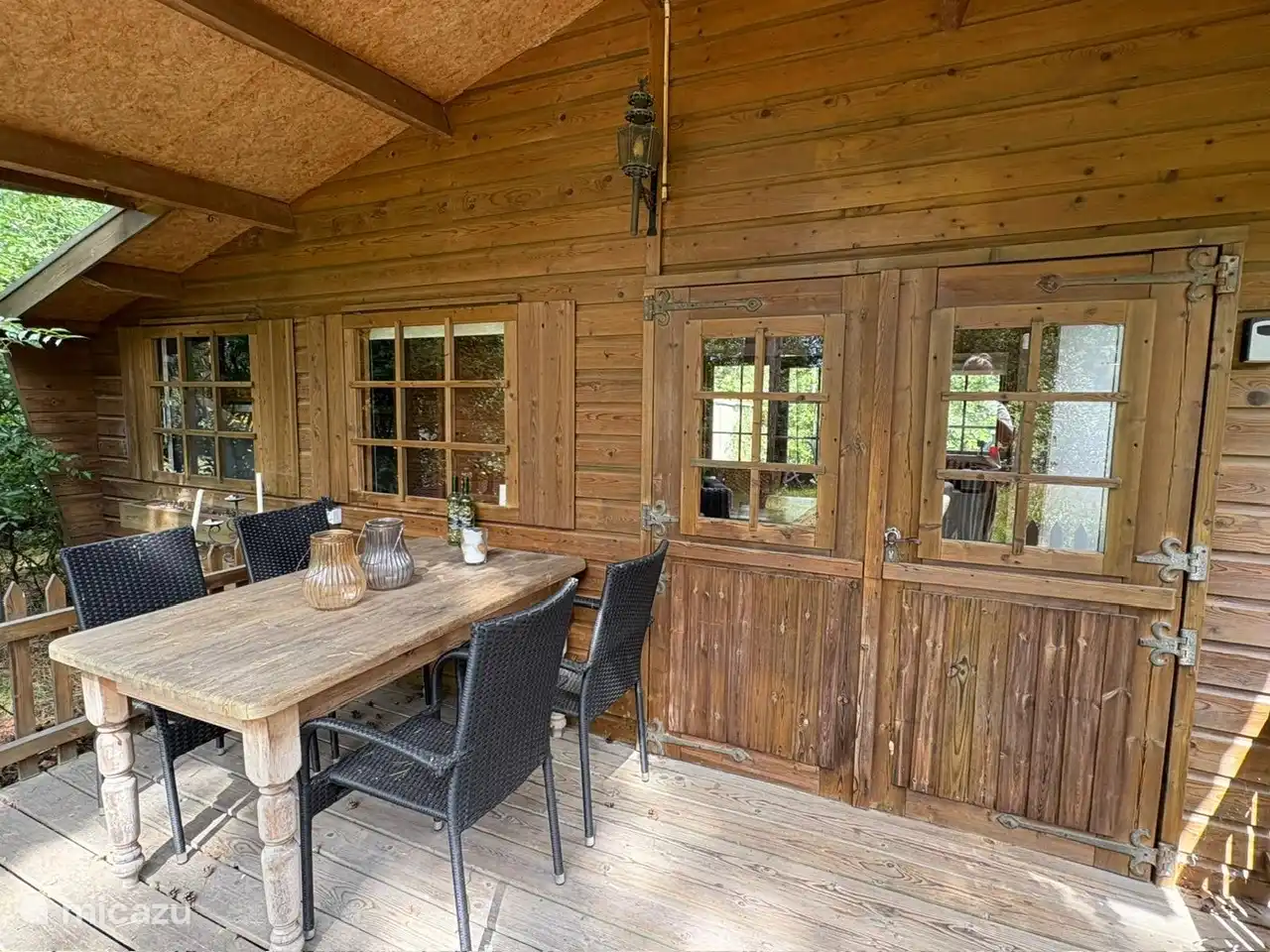 Vordere Veranda mit Esstisch (und Blick auf die Bäume und den Campingplatz)