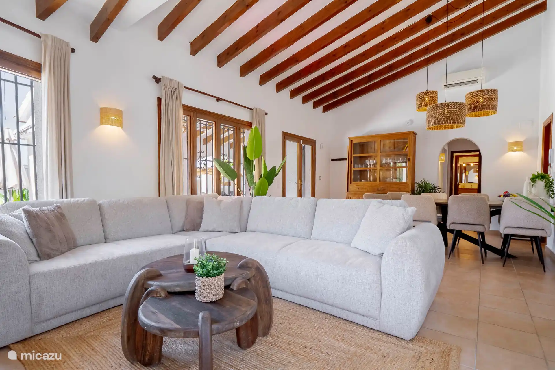 The bright living room with Spanish ceiling has a lovely corner sofa.