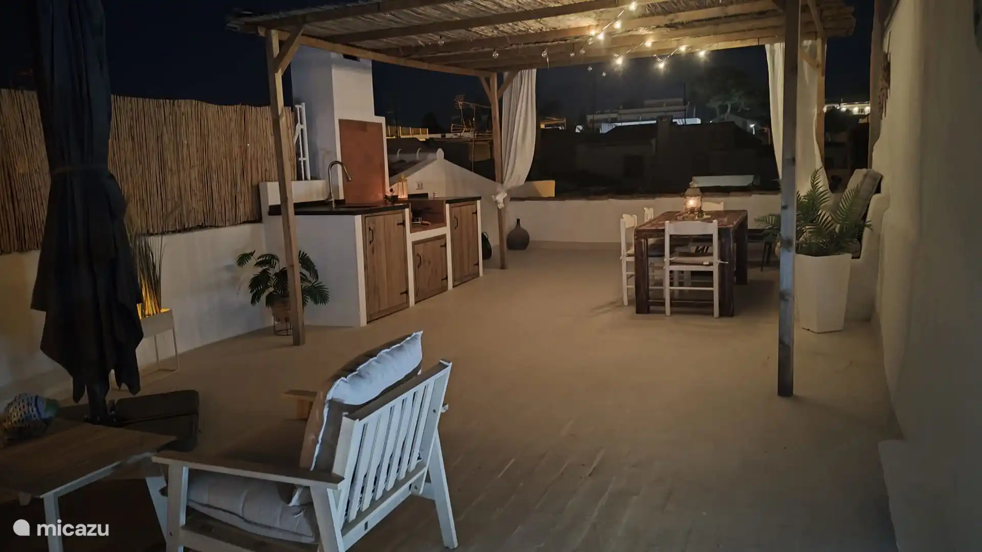 Dachterrasse am Abend mit K&#252;che (Grill, Paella, K&#252;hlschrank in der K&#252;che), Esstisch 8p und sch&#246;ner privater Sitzecke mit gro&#223;em Sonnenschirm 