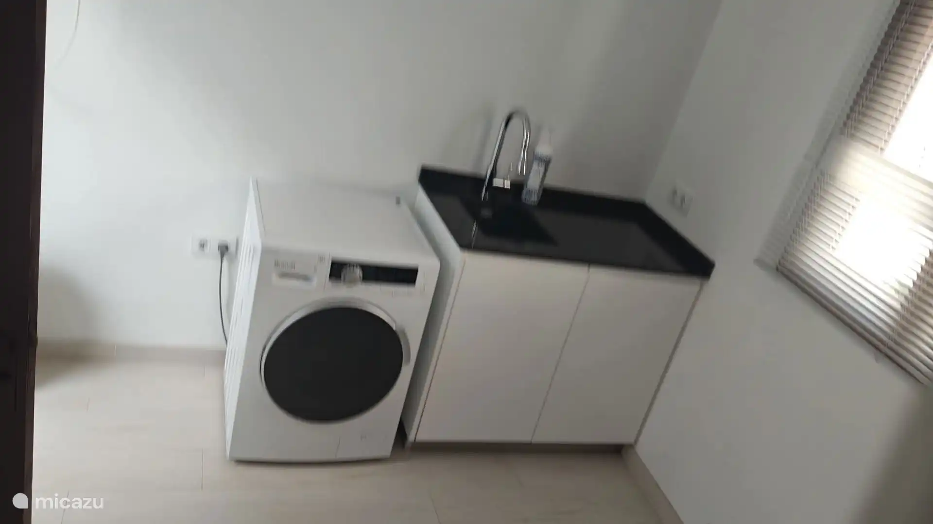 Ger&#228;umige Waschk&#252;che mit Waschmaschine und kleiner K&#252;chenzeile