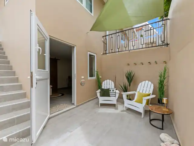 Appartement Mambo Beach | Curaçao, Banda Ariba (est), Bapor Kibra - appartement La terrasse offre deux places assises, de jolies plantes et un auvent - l’endroit idéal pour se détendre autour d’un verre.