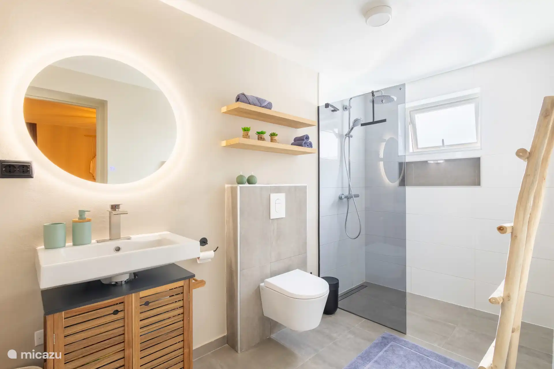 Modernes Badezimmer mit luxuriöser Regendusche, stilvollem Waschbecken sowie LED-Spiegel und Toilette.