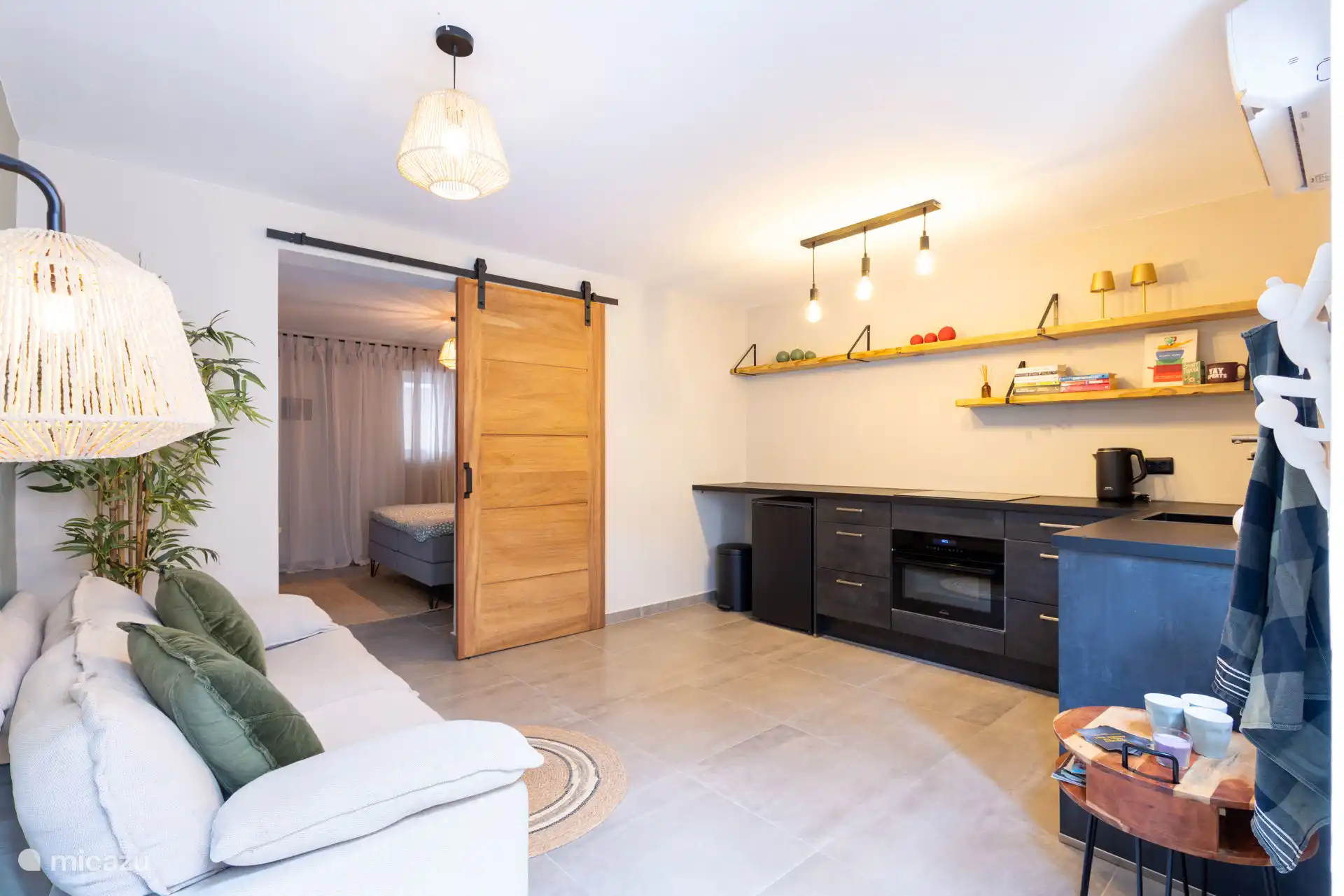 Vom Wohnzimmer aus kann man direkt zum Schlafzimmer und zur privaten Terrasse gehen. Alles ist praktisch und ansprechend dekoriert.
