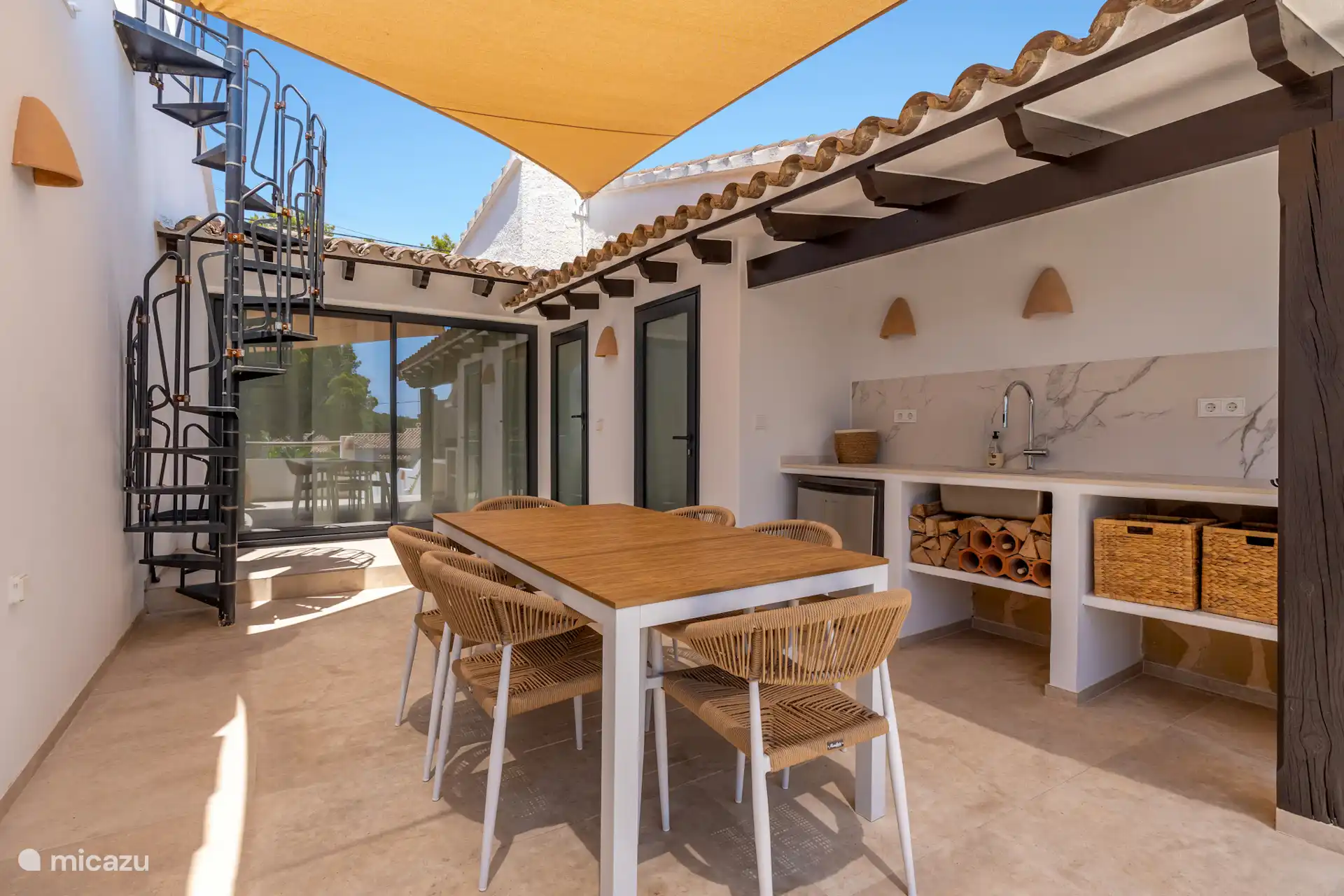 De trap gaat naar het dakterras waar een prachtig zeezicht te zien is. Boven het terras hangt een comfortabel zonnedoek