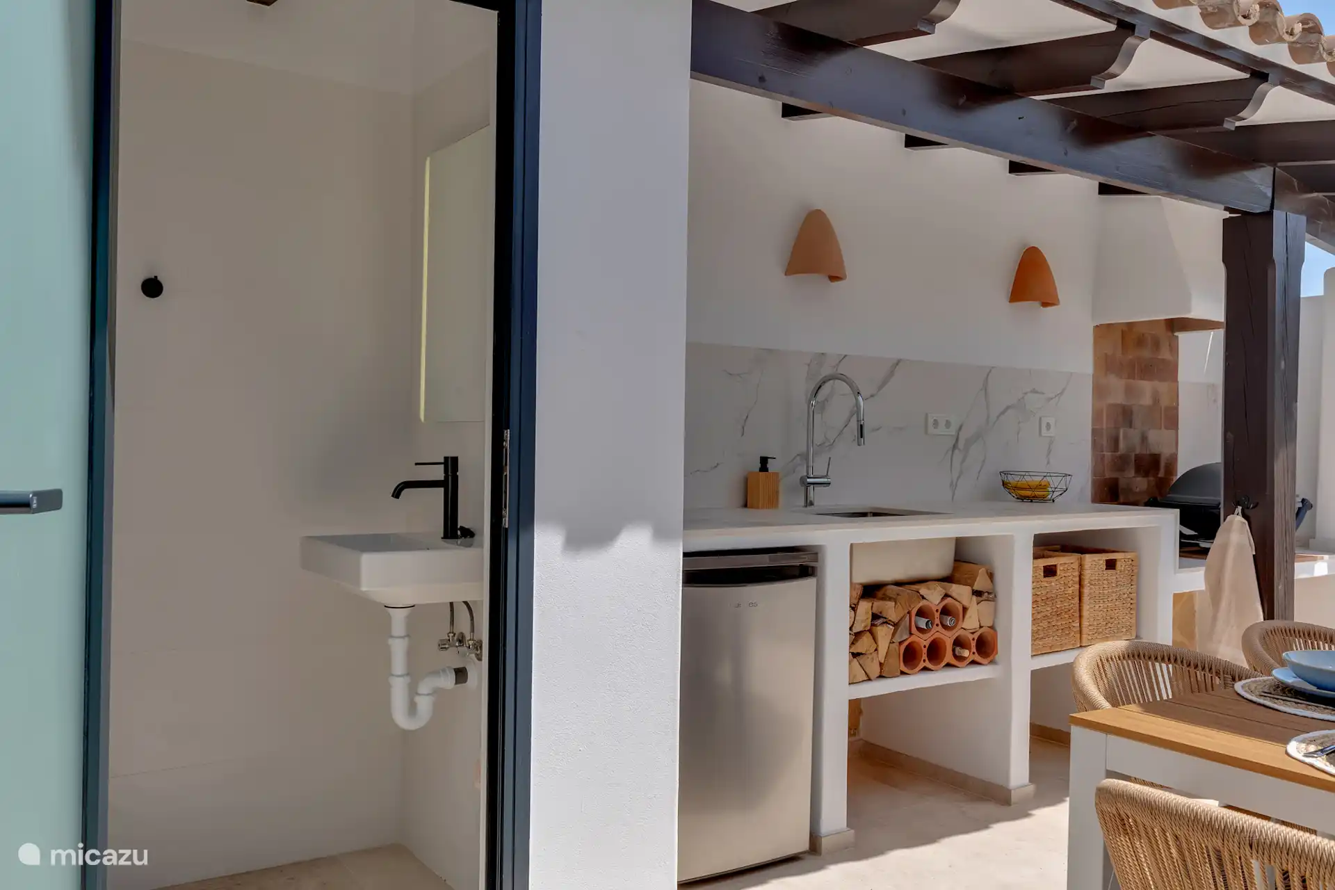 Neben der Terrasse und der Außenküche gibt es auch eine Außentoilette mit Waschbecken und Spiegel