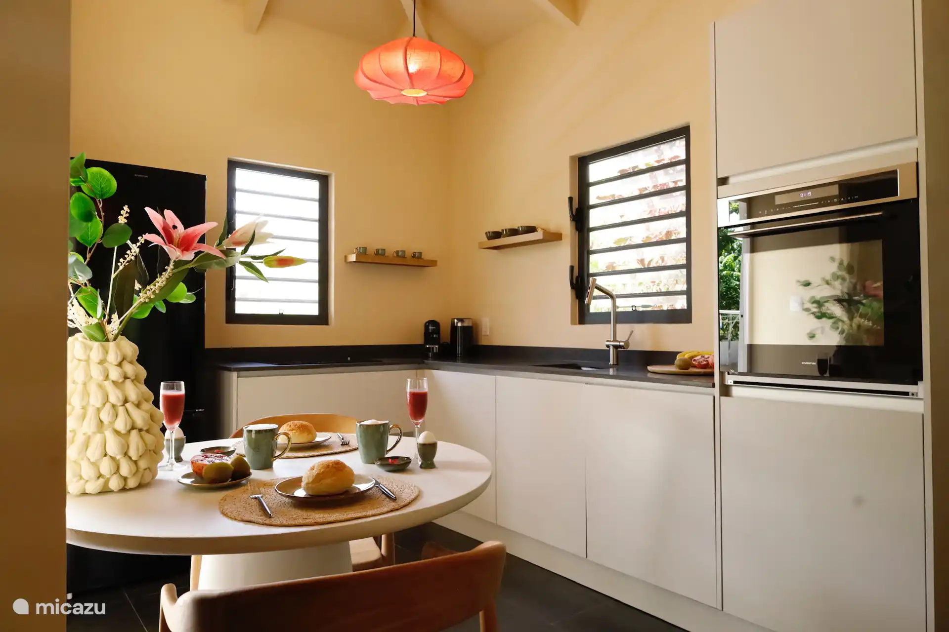 Cocina elegante y luminosa con todas las comodidades: desde horno hasta cafetera. A continuación: la mesa de comedor redonda para el desayuno o la cena.