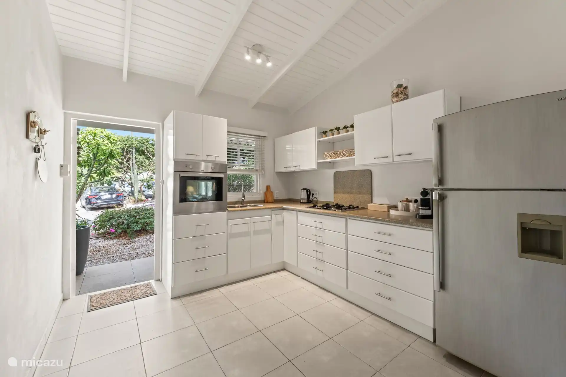 Cocina completa con horno, cafetera, gran nevera y cocina de gas.