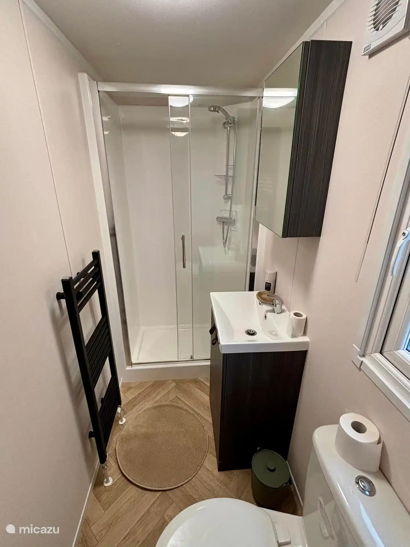 Bathroom with toilet, sink and shower.