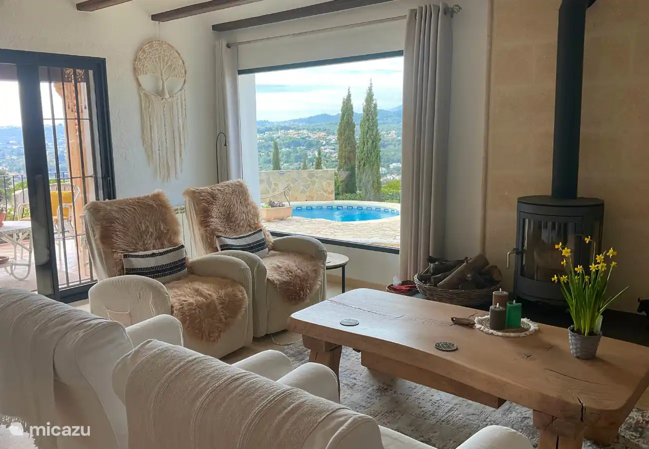 Par les portes coulissantes avec moustiquaires, vous entrez dans la terrasse couverte avec coin repas/sièges.