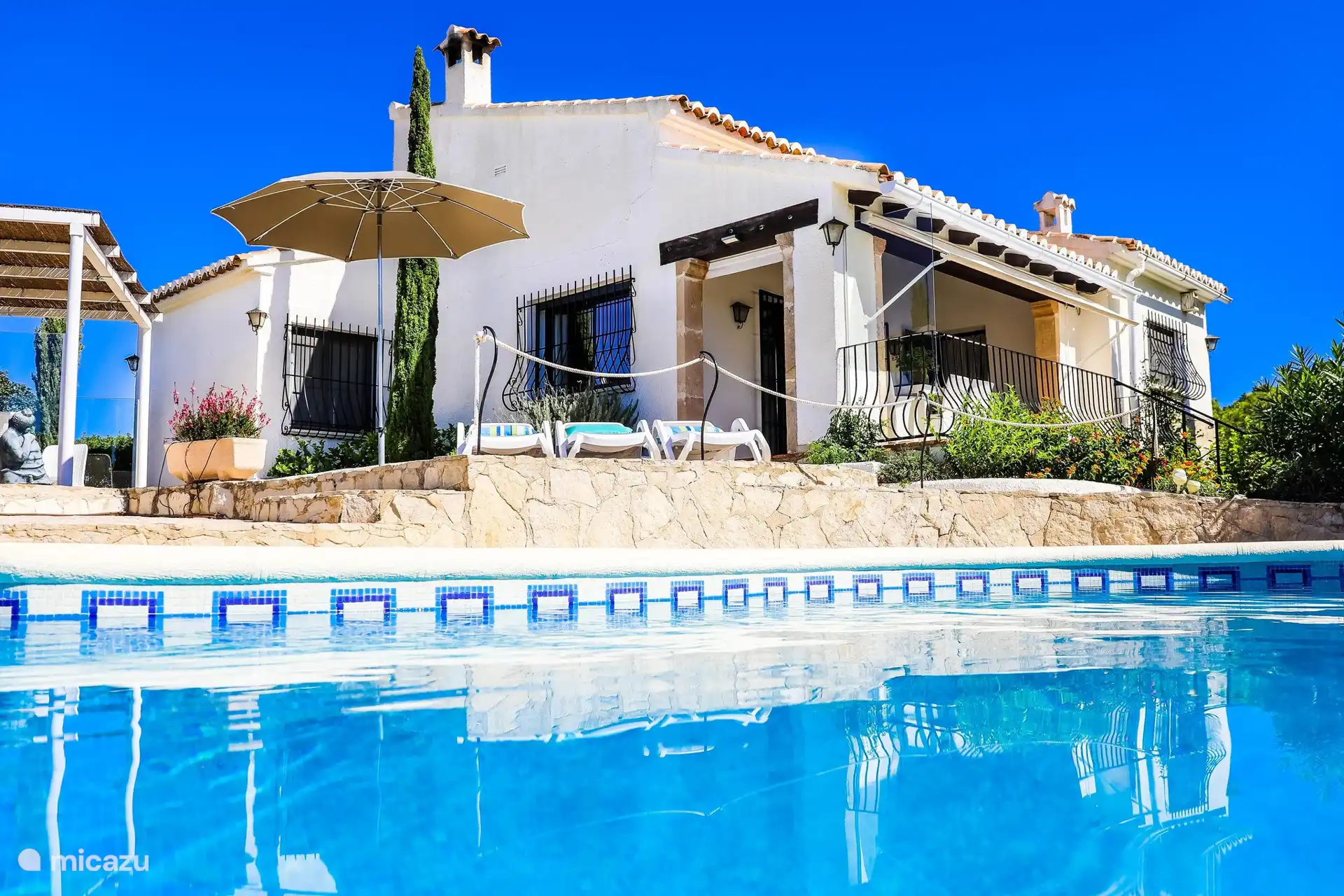 Profitez de la belle piscine en forme de rein avec six transats et d’autres meubles d’extérieur tout autour.