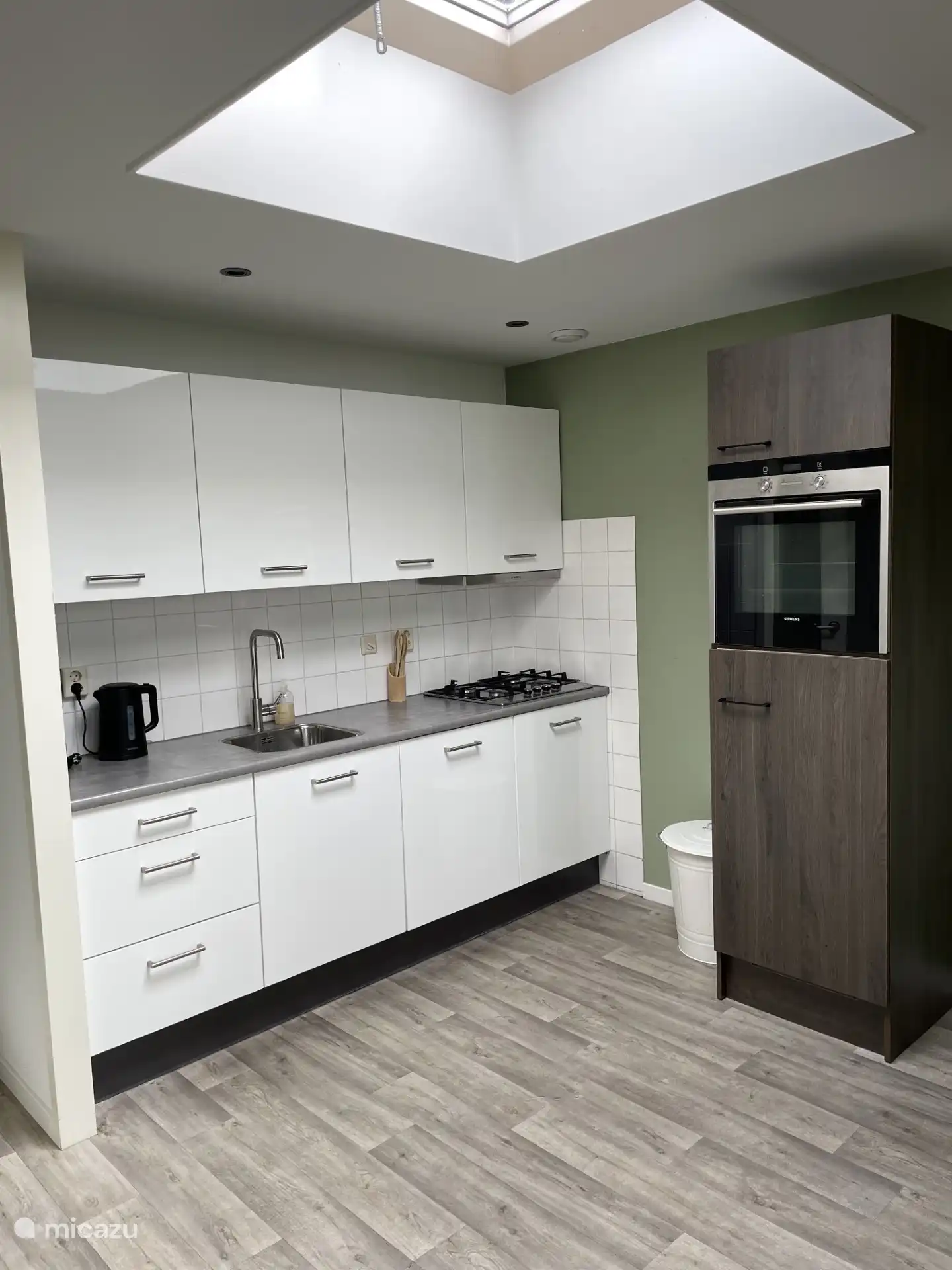 De keuken met oven, vaatwasser, waterkoker en koffiezetapparaat 