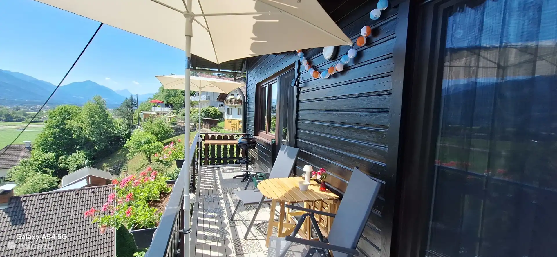 Der Balkon auf der Südseite des Hauses. Es gibt einen Elektrogrill und einen Grilltisch. Sie können den Esstisch ausklappen. Auf dem anderen Teil des Balkons befinden sich ebenfalls 2 Stühle.