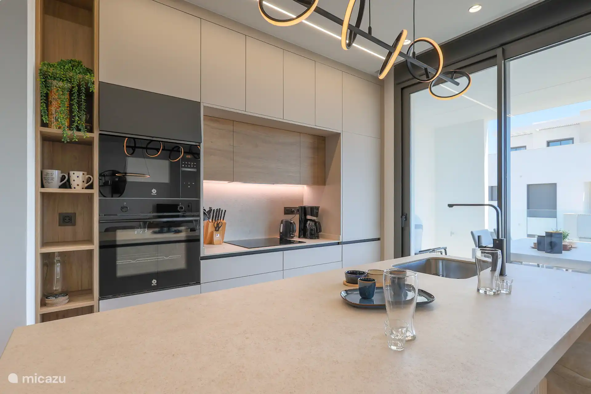 La cuisine donne également sur la terrasse et est située au centre du salon.