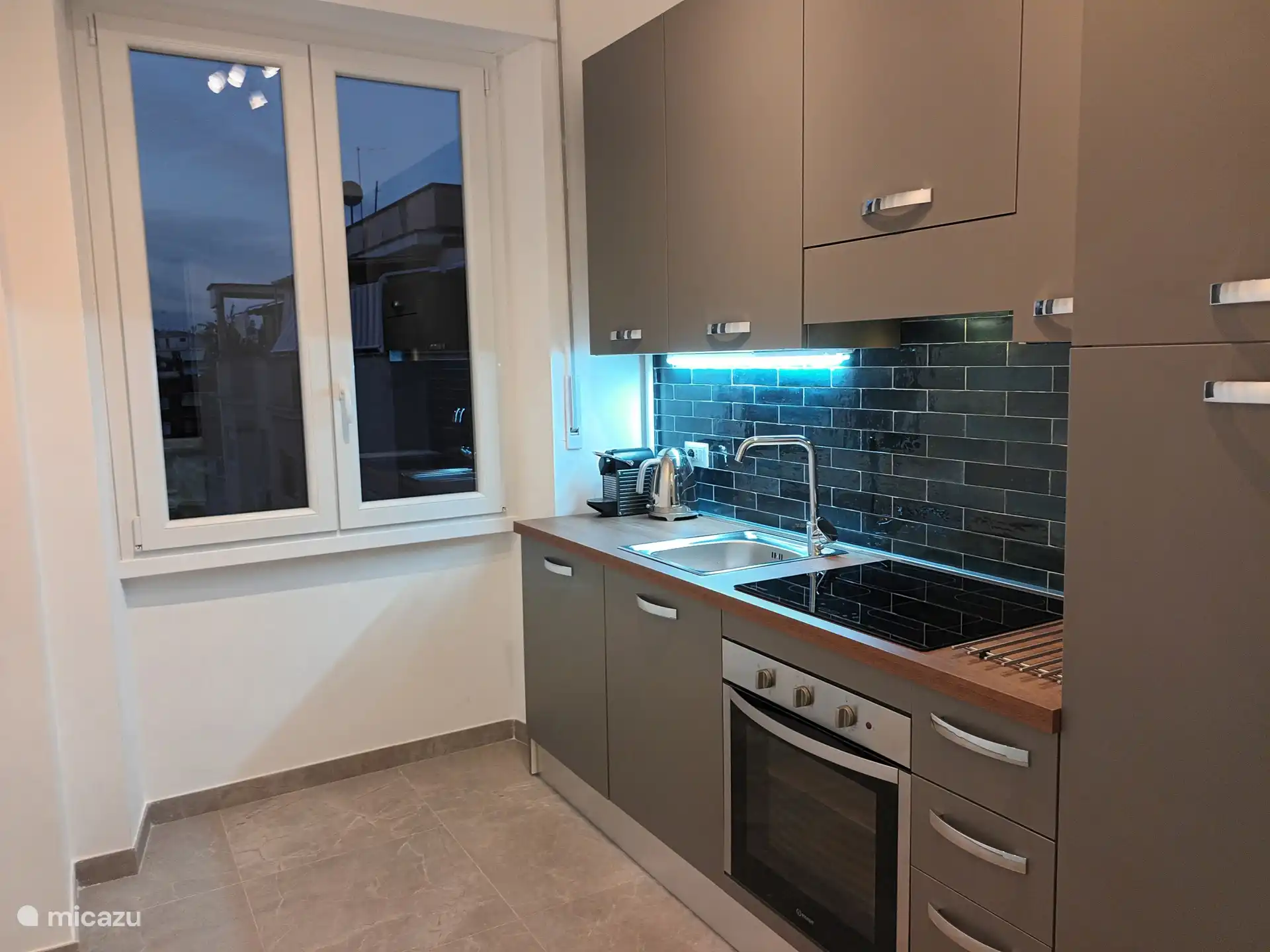 Amplia cocina independiente con fregadero, lavavajillas, placa de inducción, horno y nevera